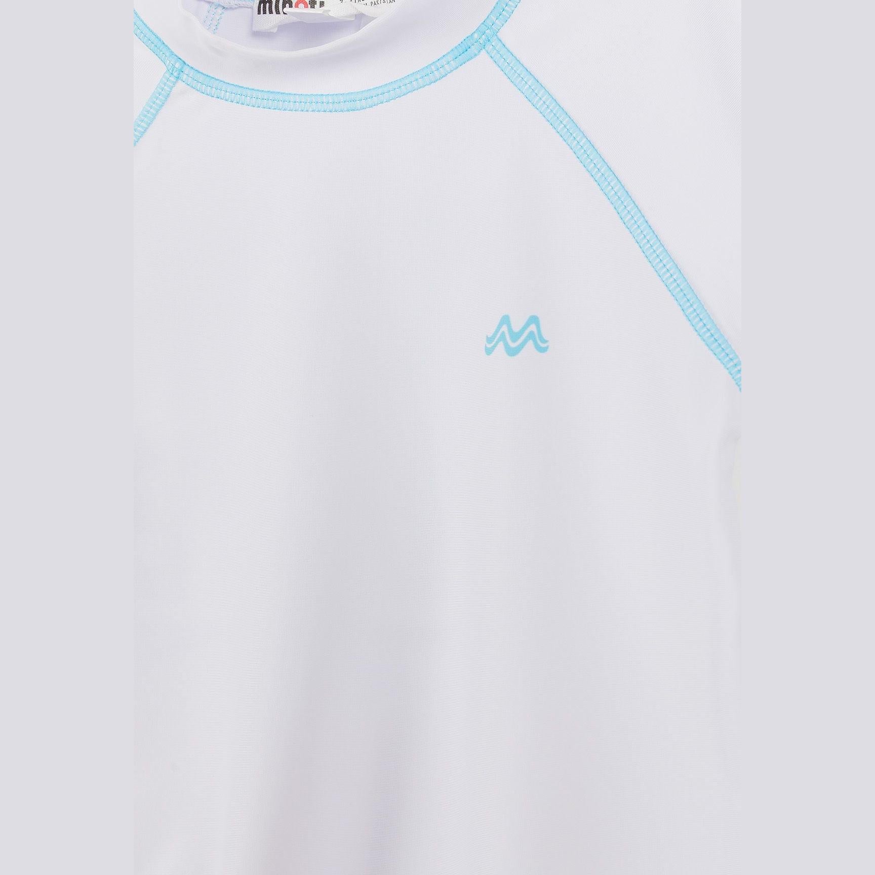 Close-up detail of white rash top showing blue contrast stitching around neckline and raglan seams, with small blue Minoti logo positioned on left chest