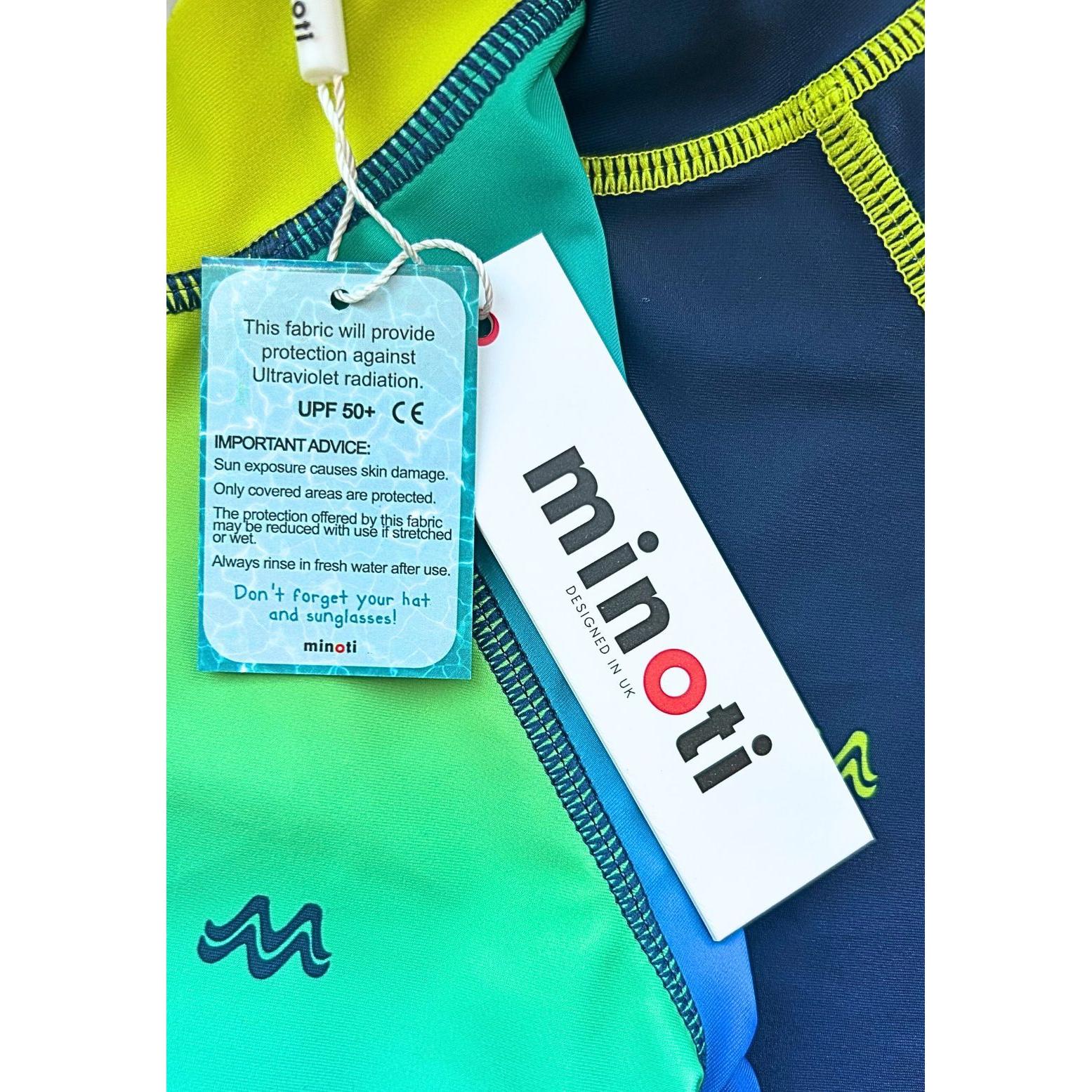 Close-up of Minoti care label and UPF 50+ protection tag attached to blue and green gradient swimwear
