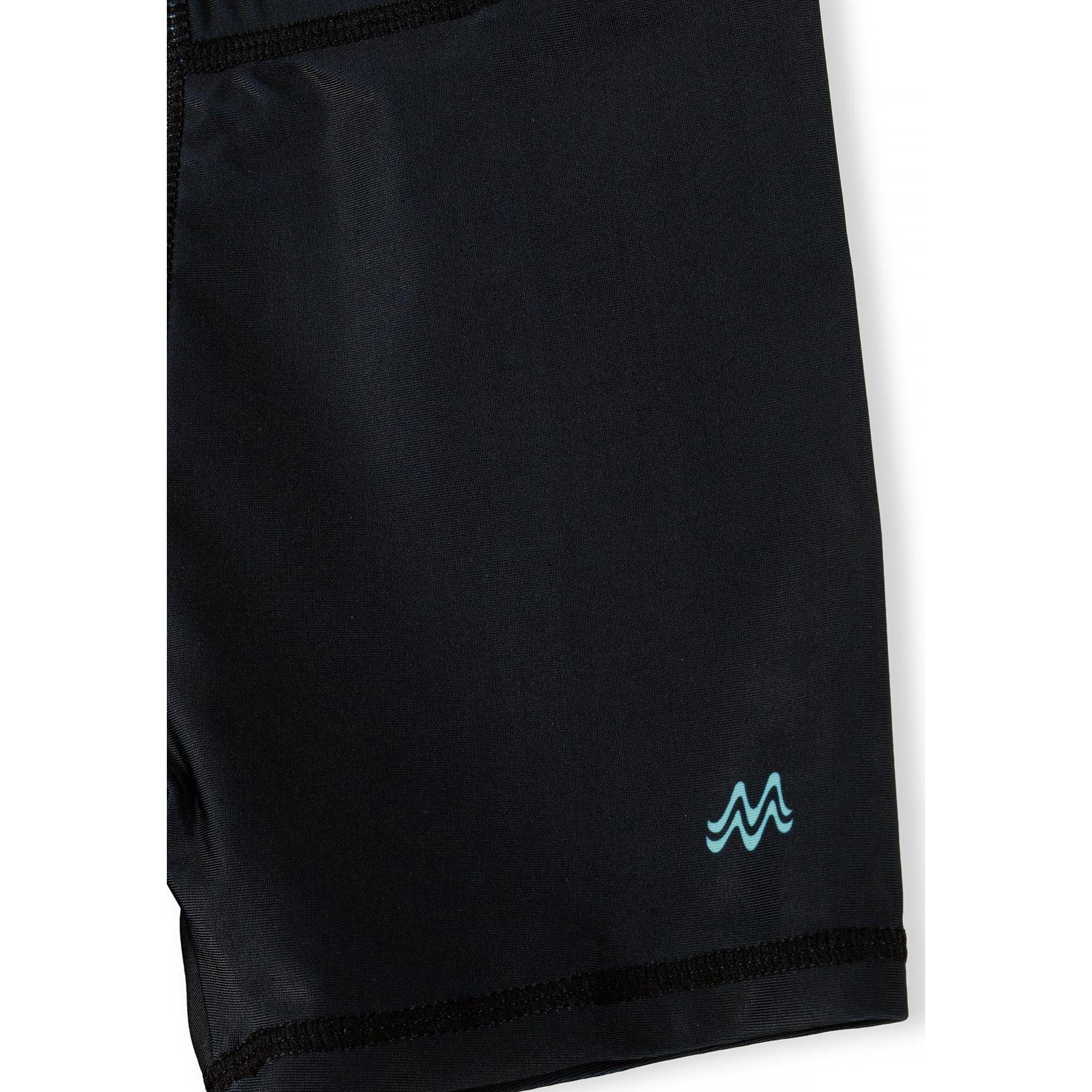 Product label and tag attached to blue gradient swim shorts showing Minoti branding and UPF 50+ fabric protection information