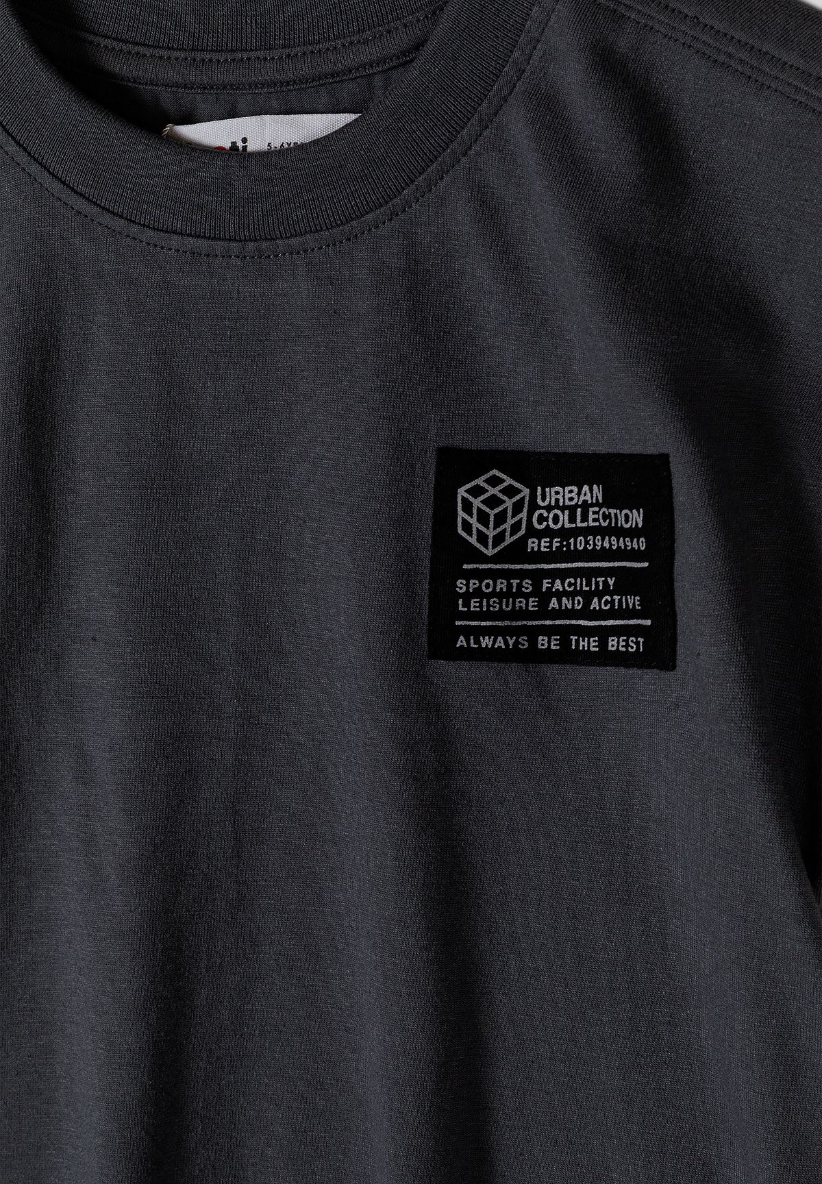 Close-up of black Urban Collection text patch on charcoal T-shirt chest.