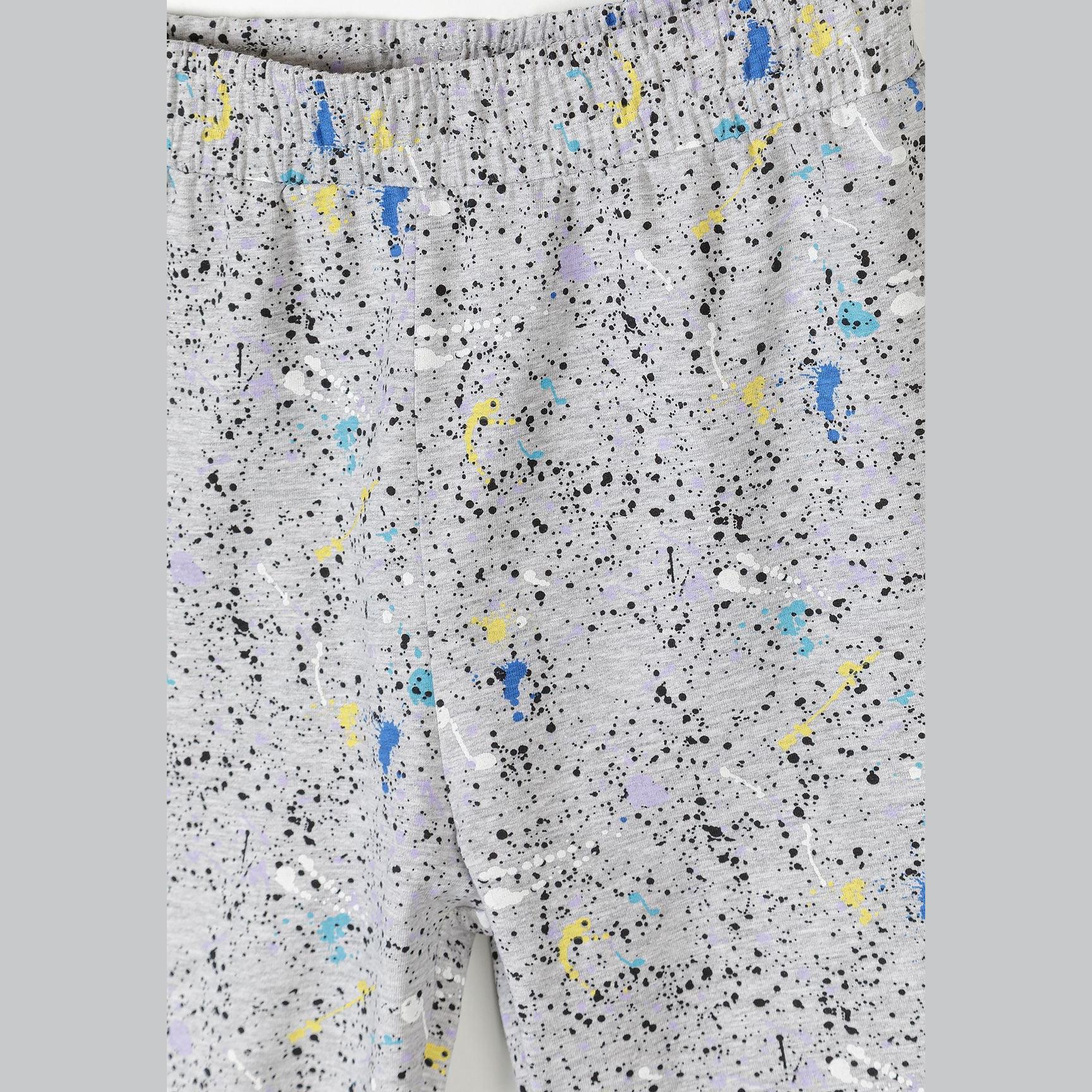 Detail shot of grey shorts with colorful splatter pattern featuring blue, yellow, purple and black paint splashes on light grey fabric