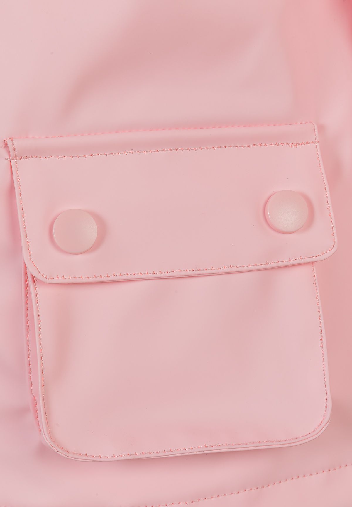 Detail of a pink waterproof jacket with a snap button pocket.