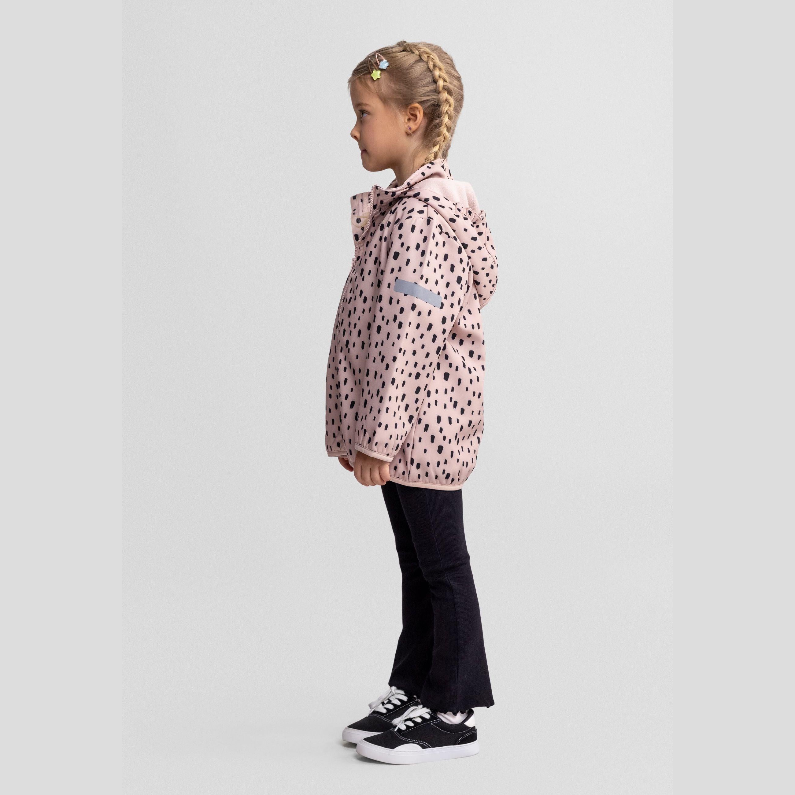 Close-up detail of pink fabric with black spotted pattern showing front pocket with stitched edges and fabric texture