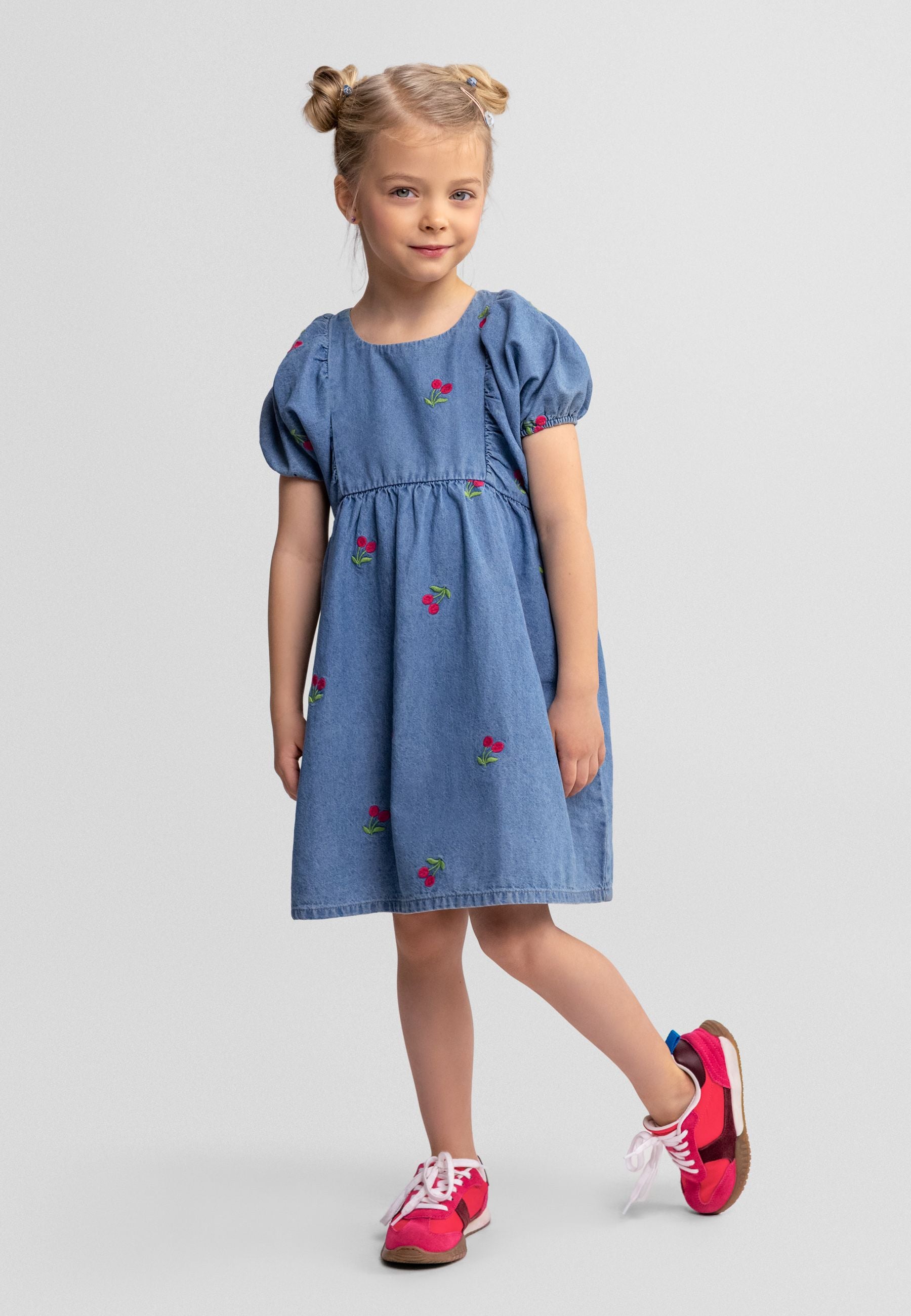 Girls denim dress in blue with cherry embroidery, front view.