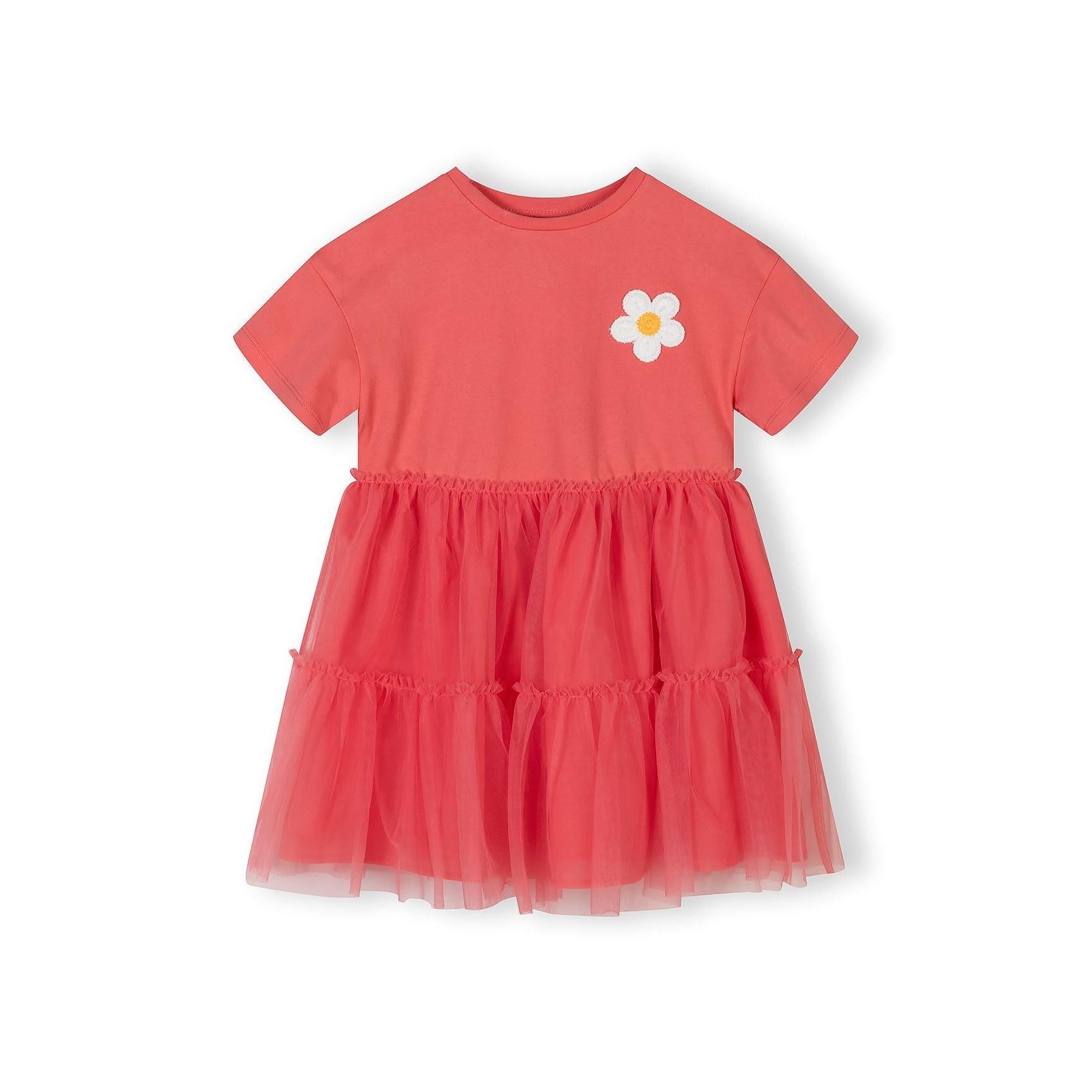 Back view of coral tulle dress showing tiered tulle skirt layers and cotton jersey bodice construction on white background