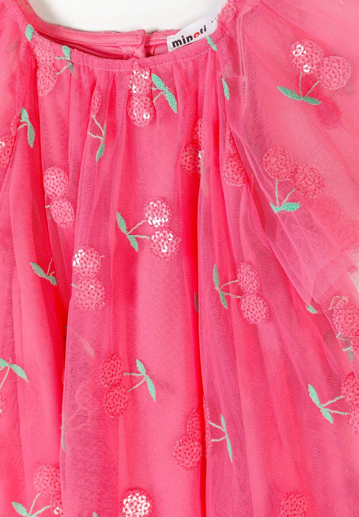 Close-up of a pink tulle party dress with cherry embroidery and angel sleeves.