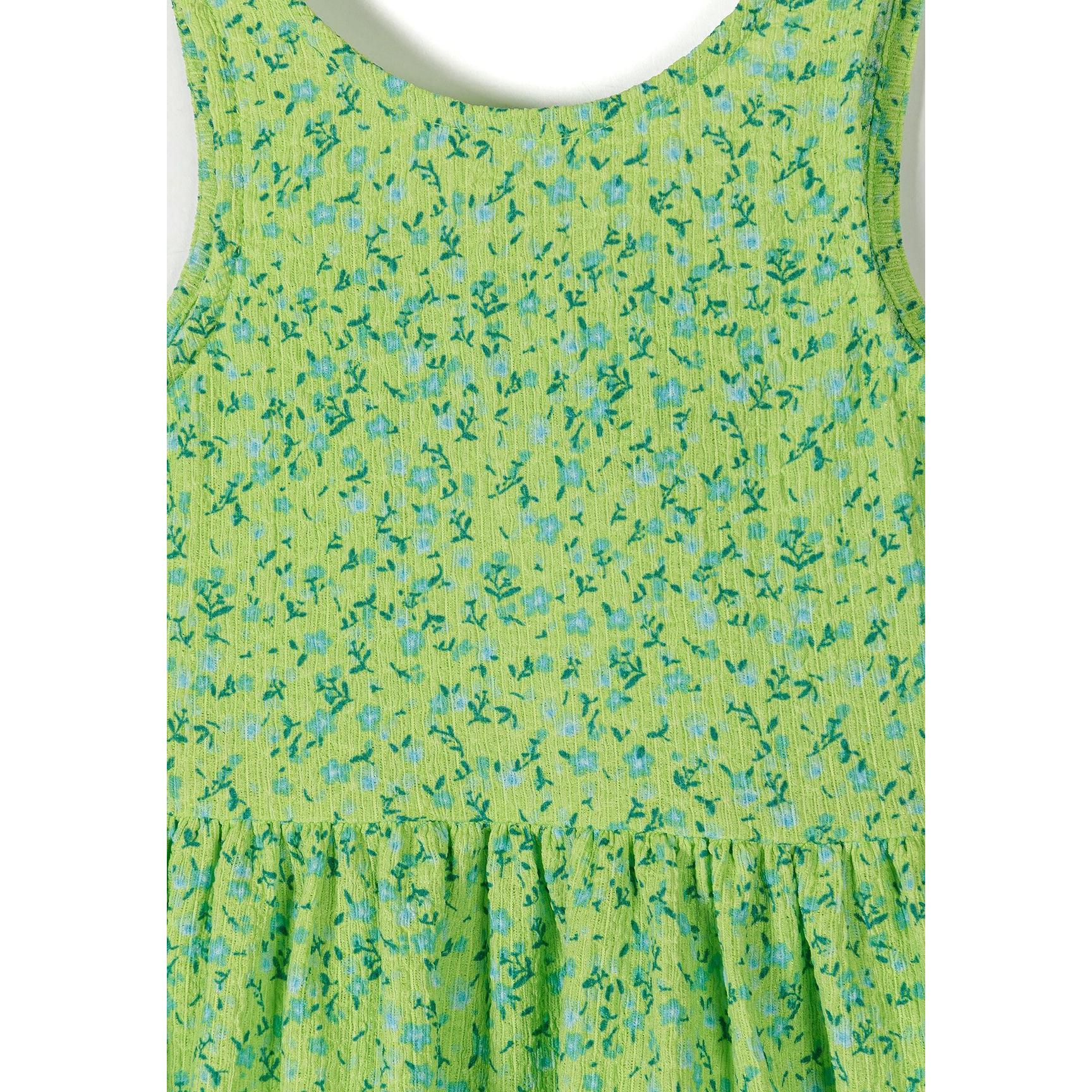 Close-up detail of emerald green fabric with small blue and teal floral pattern, showing texture and tie-back waist detail