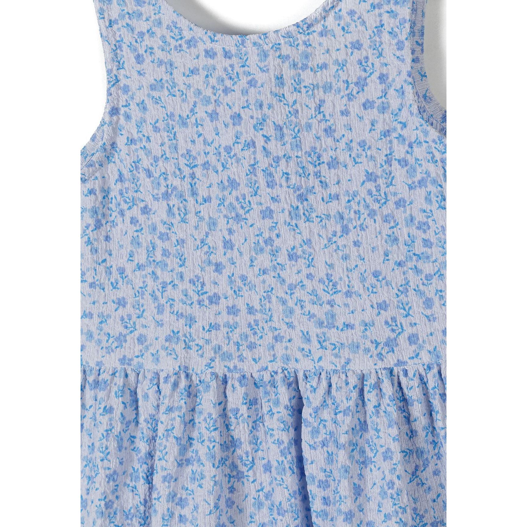 Close-up detail of blue floral pattern and tiered construction of sleeveless dress bodice