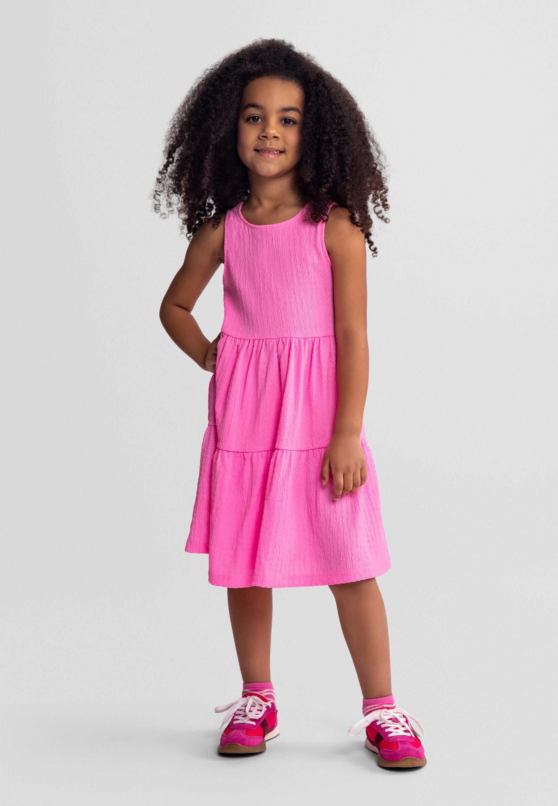 Girls sleeveless pink tiered summer dress, front view, adjustable fit.