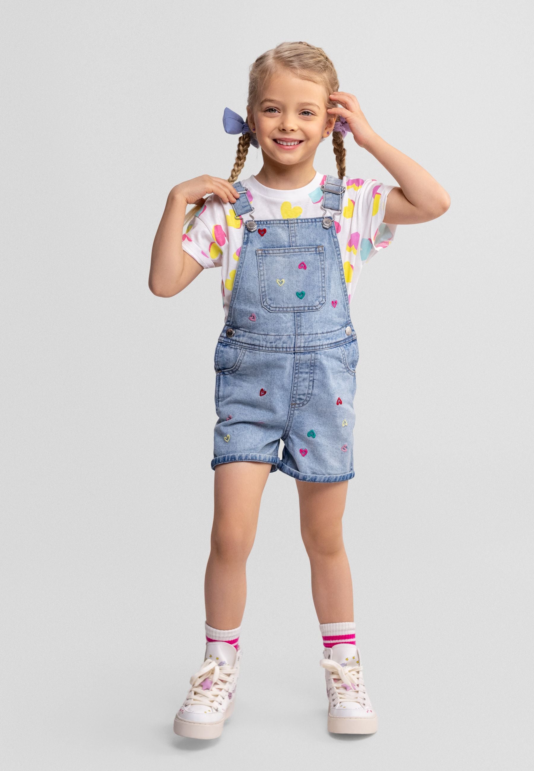 Girls' blue denim dungaree with floral embroidery, front view, adjustable straps.