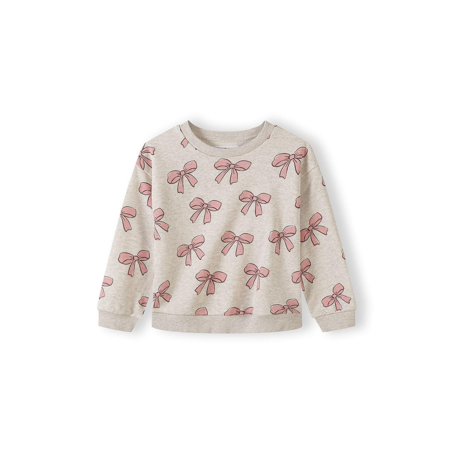 Beige girls sweatshirt with pink bow print pattern displayed flat on white background, showing ribbed cuffs and hem details