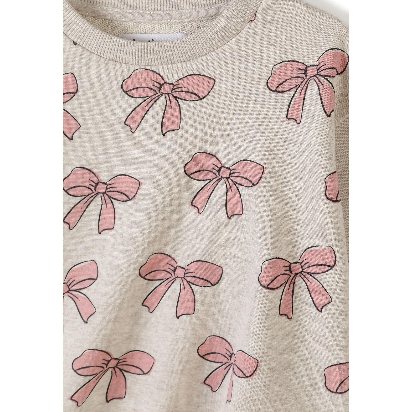 Close-up detail of pink sweatshirt showing cute bunny character graphic with striped ears, bow tie and black and white striped outfit