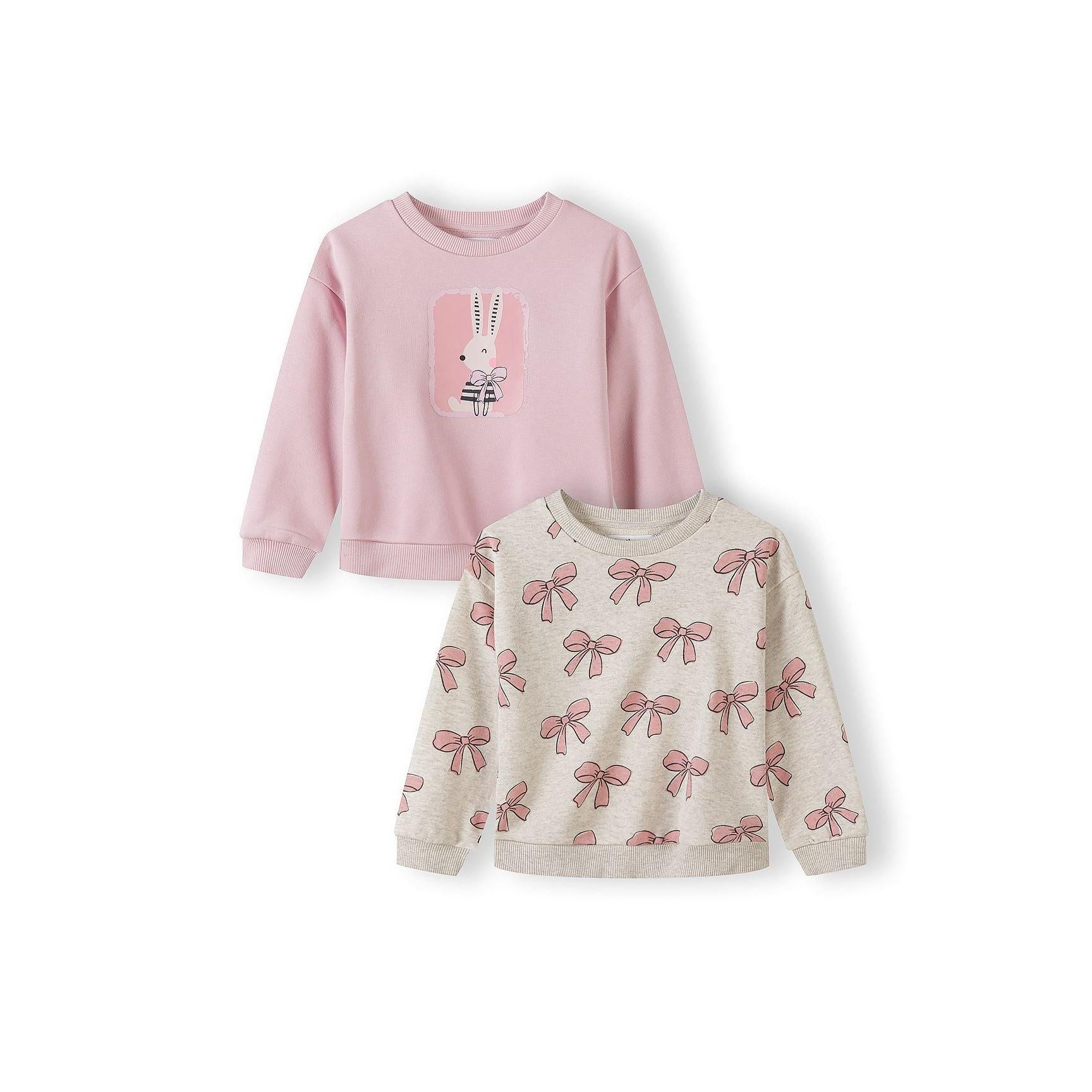 Two girls sweatshirts on white background - pink sweatshirt with bunny graphic on top, beige sweatshirt with bow print pattern below