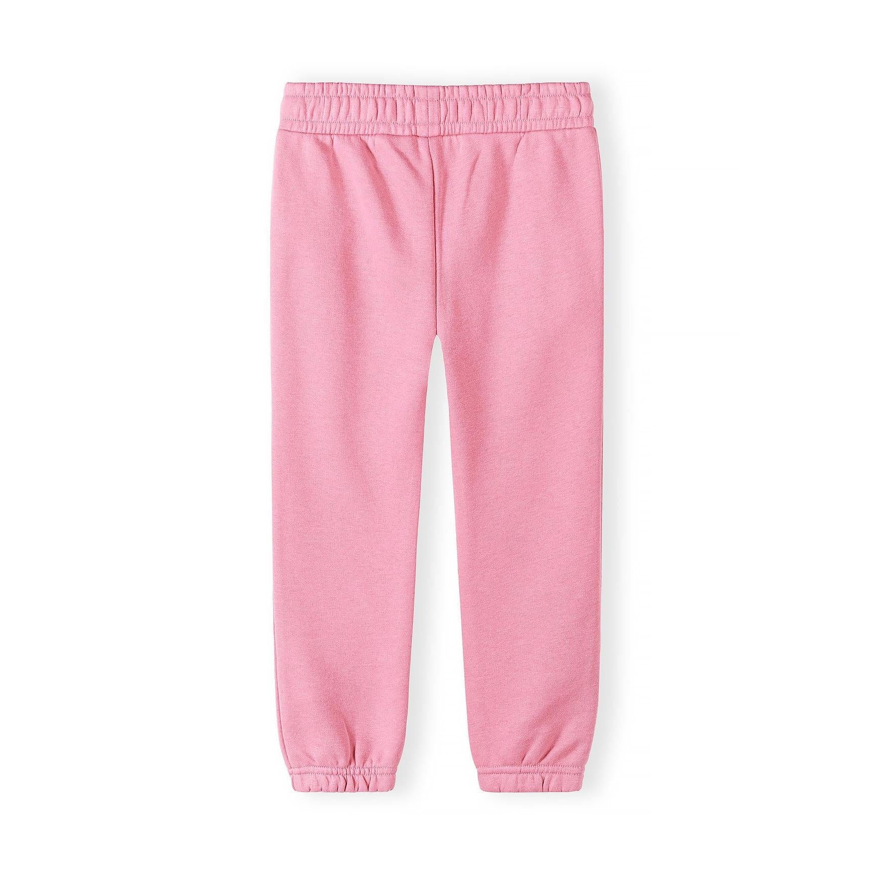 Close-up detail of coral pink jogger showing Minoti label on elasticated waistband and soft knit fabric texture