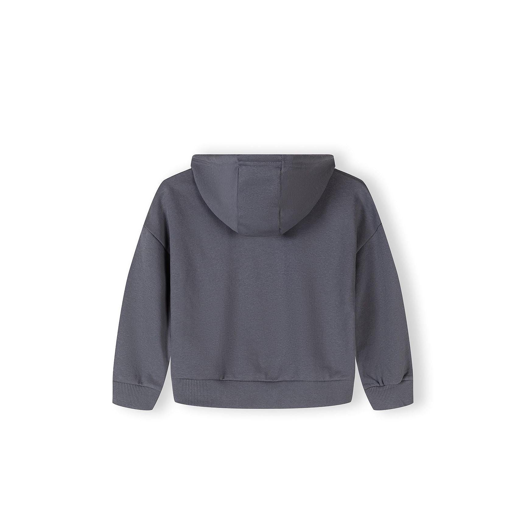Close-up of blue-grey tracksuit bottoms showing elastic waistband and CALI USA Dance Studio text print on the leg