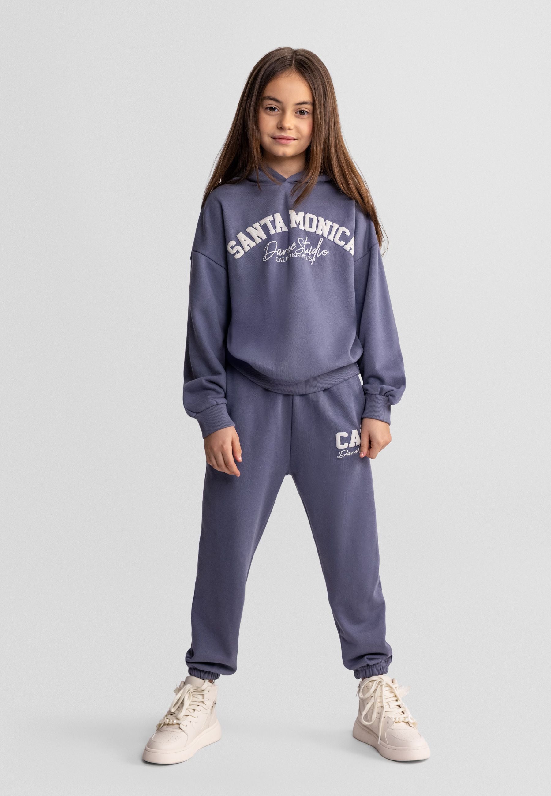 Girls' blue-grey hooded tracksuit with tapered trousers, featuring logo details.