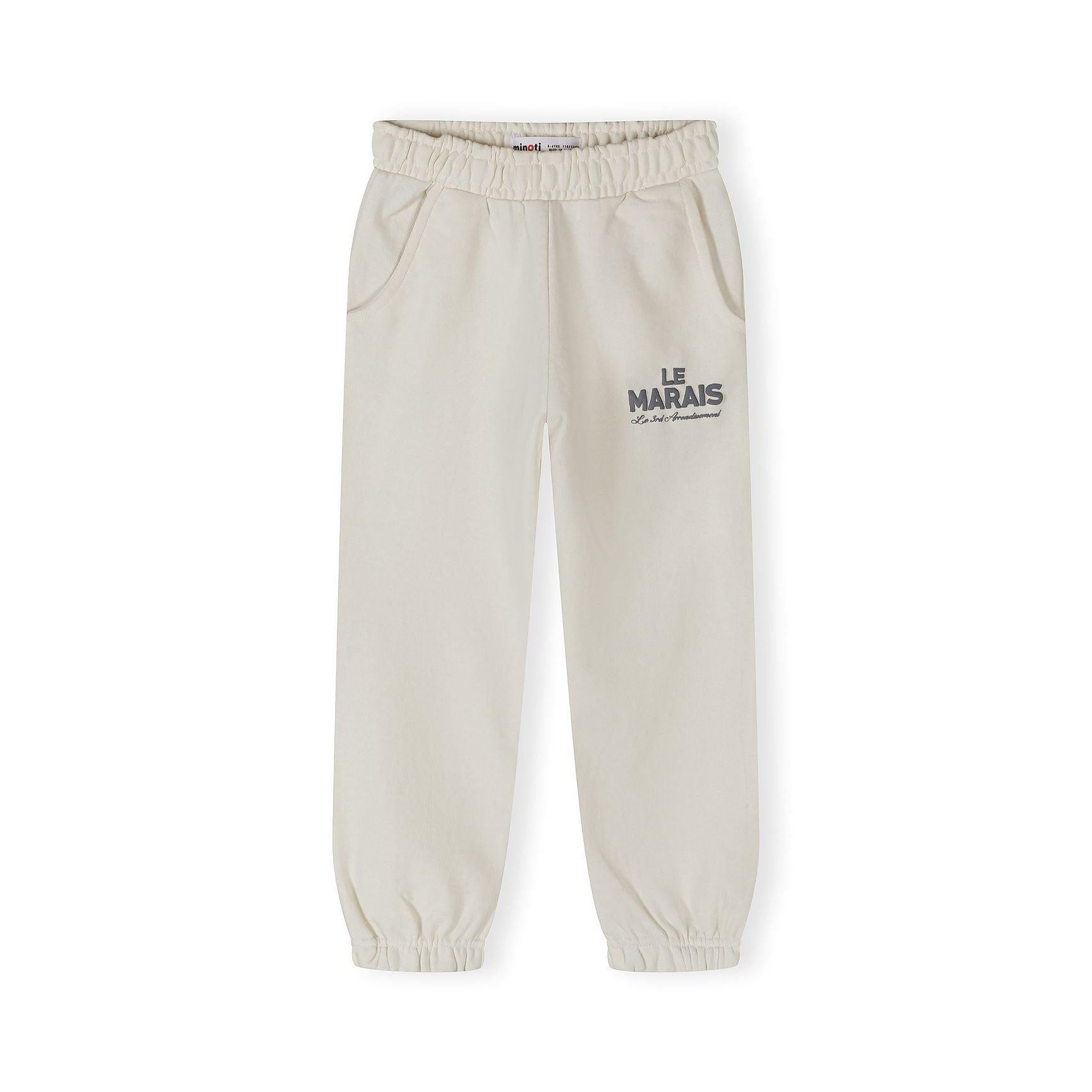 Close-up detail of off white joggers showing elastic waistband and Le Marais text print on leg