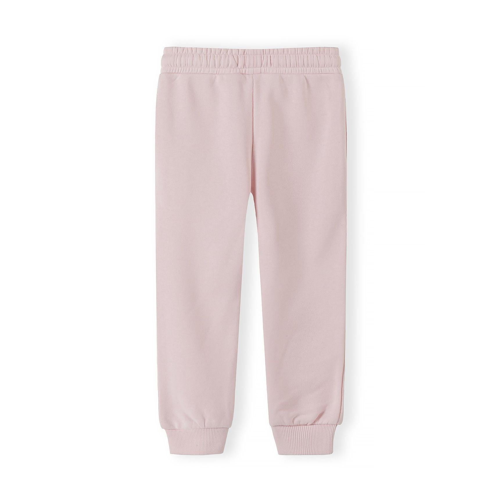 Close-up detail of light pink joggers showing elastic waistband with white drawstring and Minoti label on pink fabric background