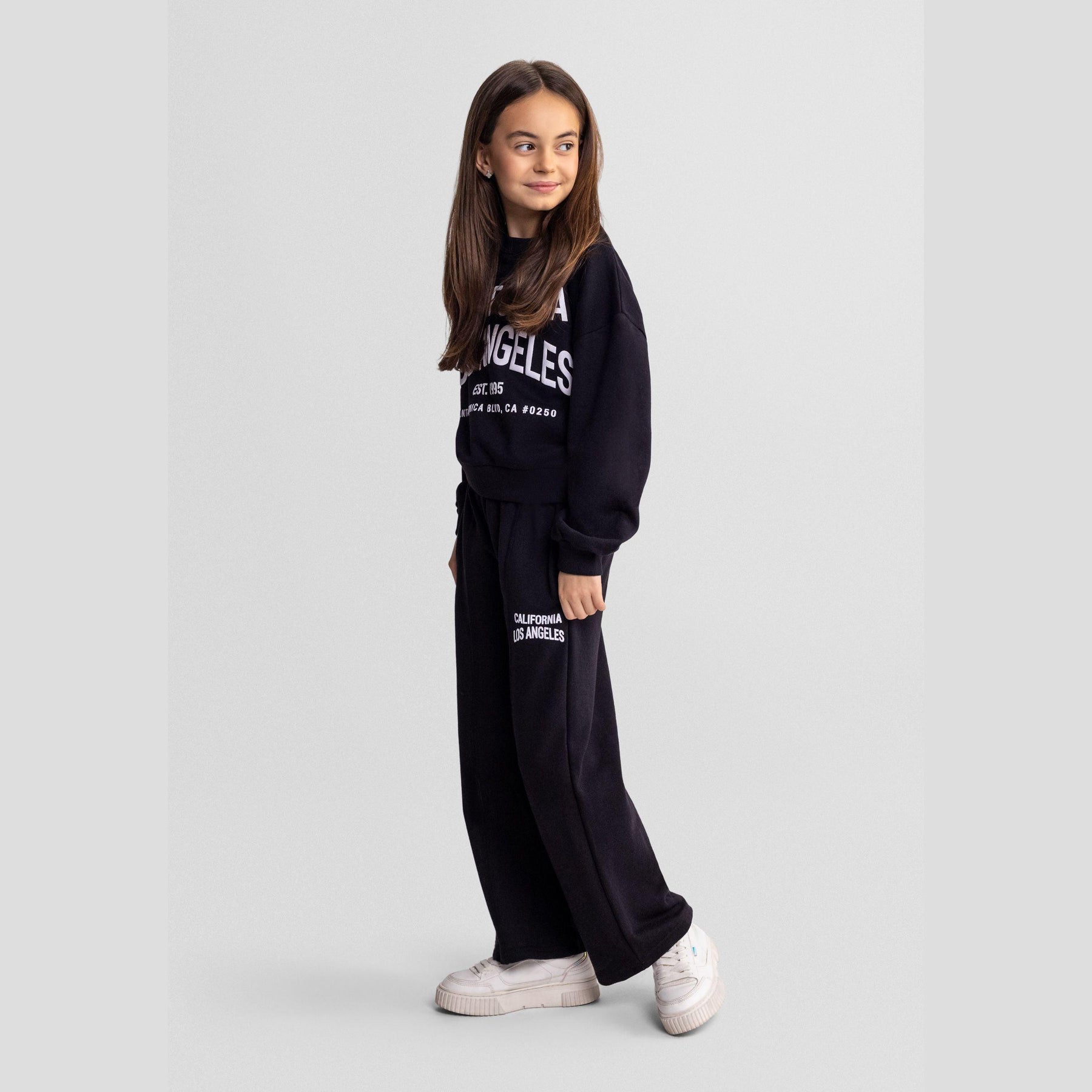 Black crew neck sweatshirt with white California Los Angeles EST 1995 Santa Monica Blvd CA 90250 text print, shown flat against white background