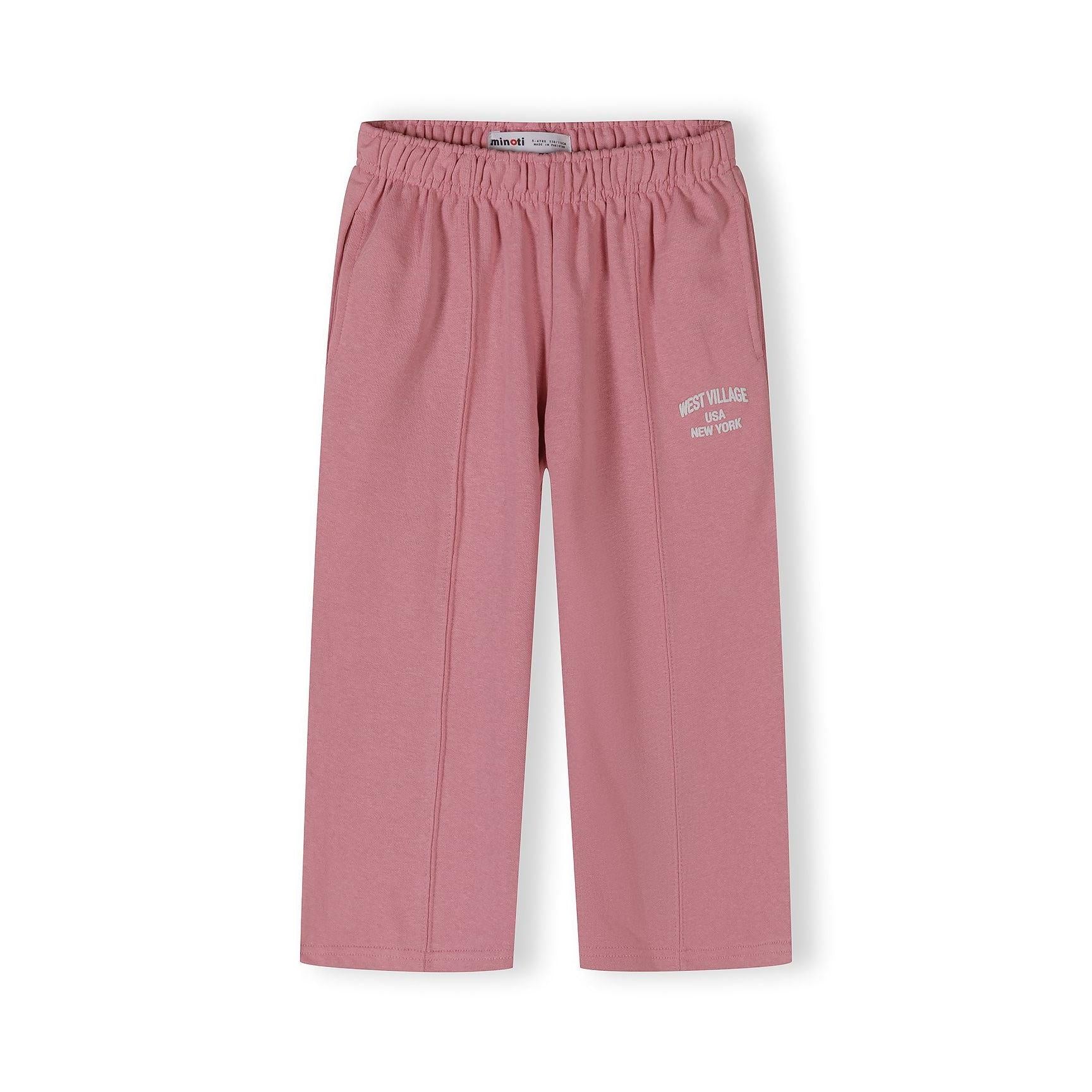 Close-up view of pink wide-leg joggers with elastic waistband and West Village USA New York print detail on white background
