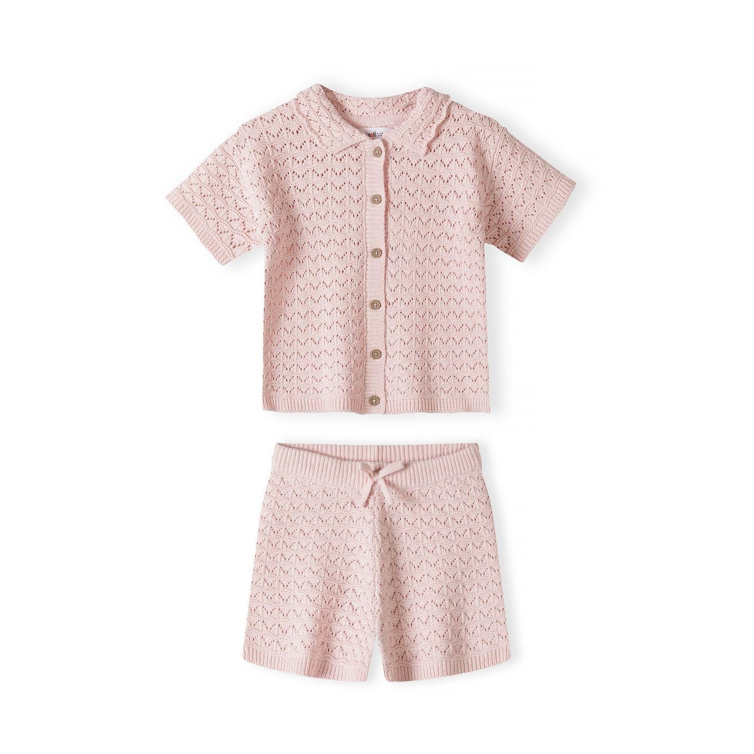 Close-up detail of blush pink pointelle knit showing button placket with light colored buttons and Minoti brand label