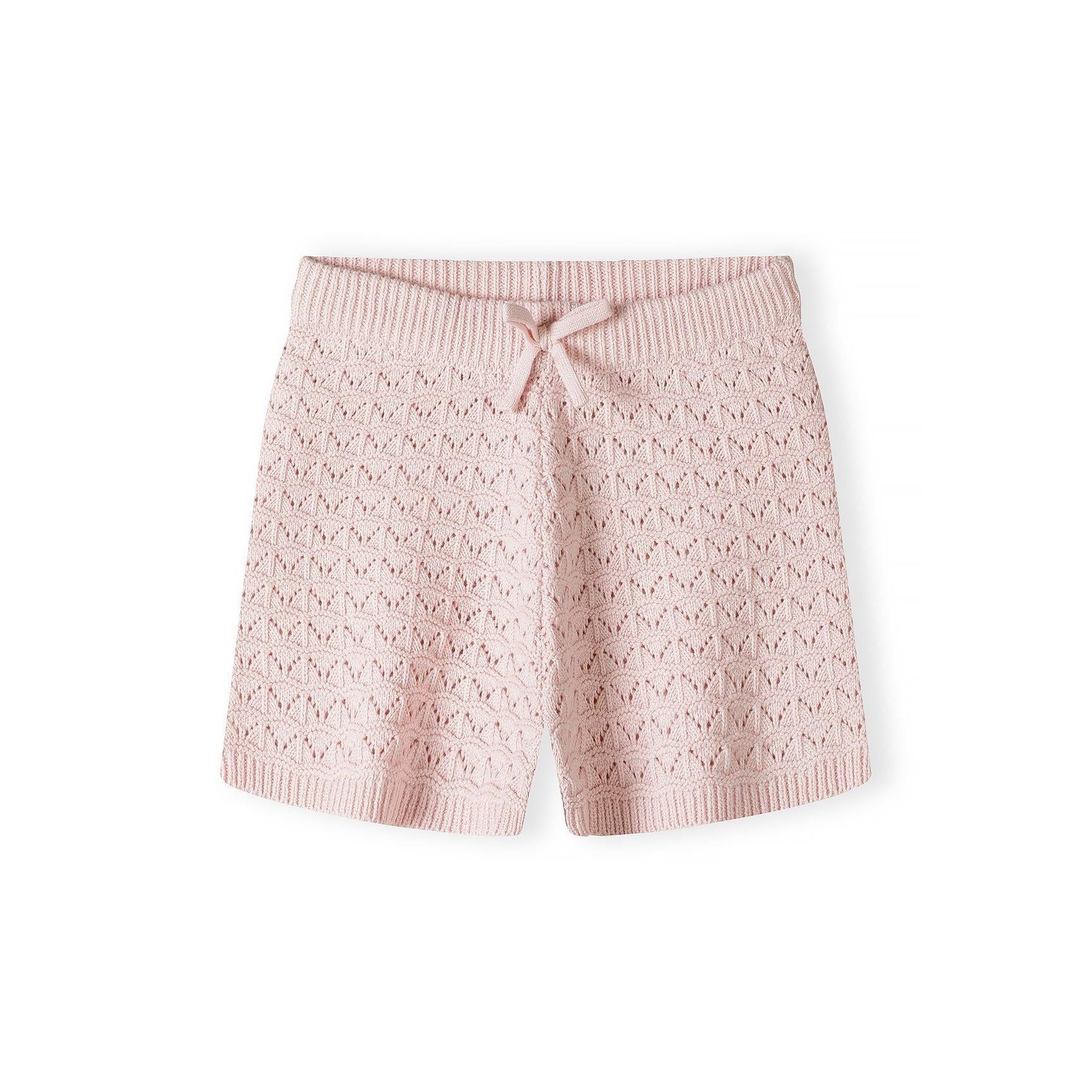 Close-up detail of blush pink pointelle knit showing button placket with light colored buttons and Minoti brand label