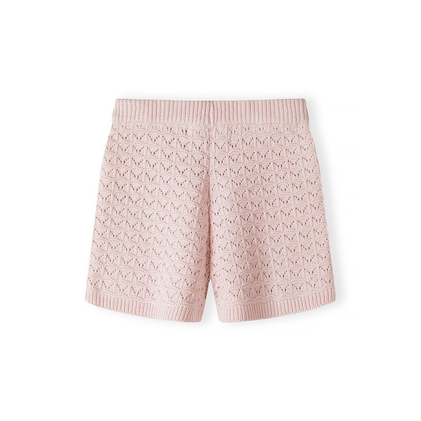 Close-up detail of blush pink pointelle knit showing button placket with light colored buttons and Minoti brand label