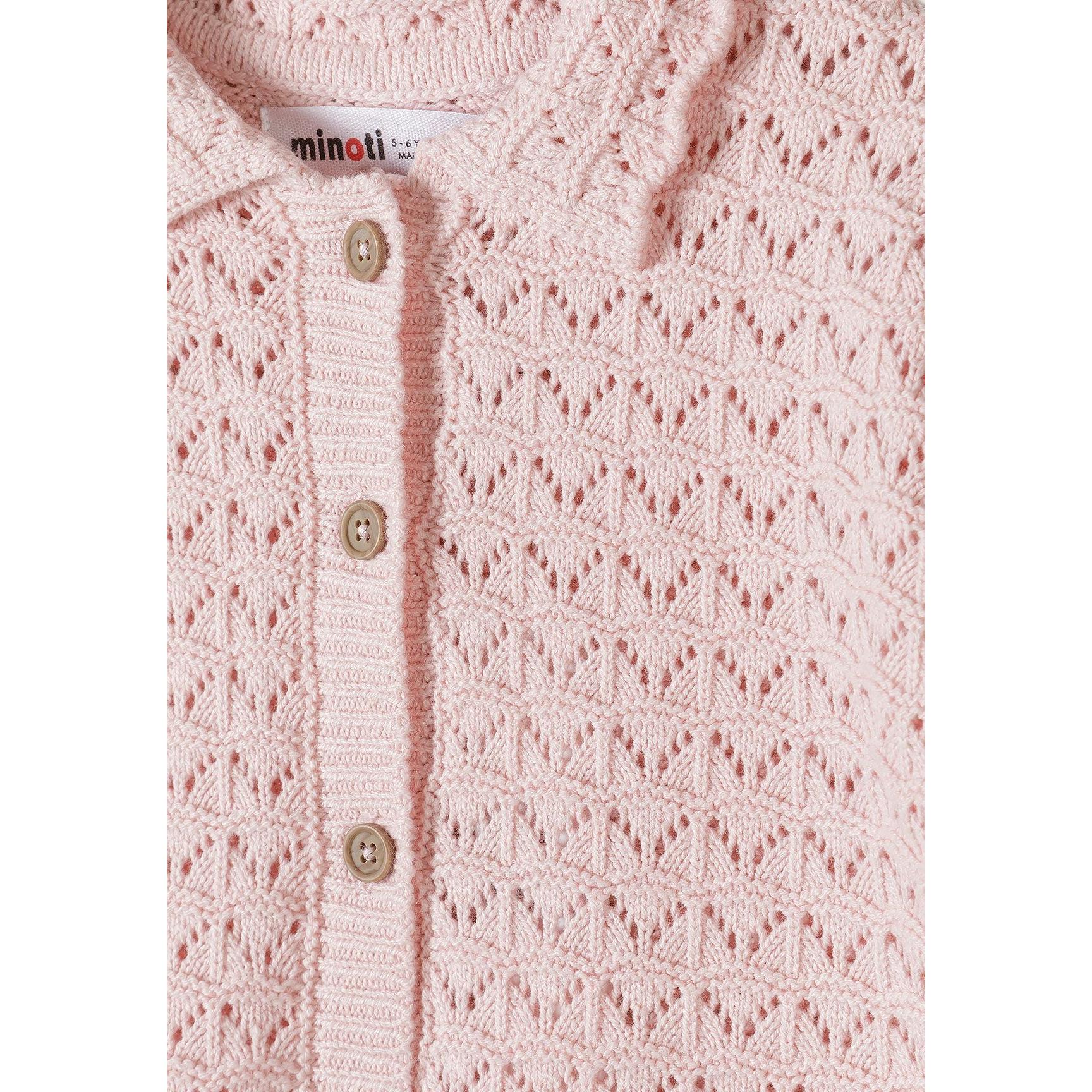 Close-up detail of blush pink pointelle knit showing button placket with light colored buttons and Minoti brand label