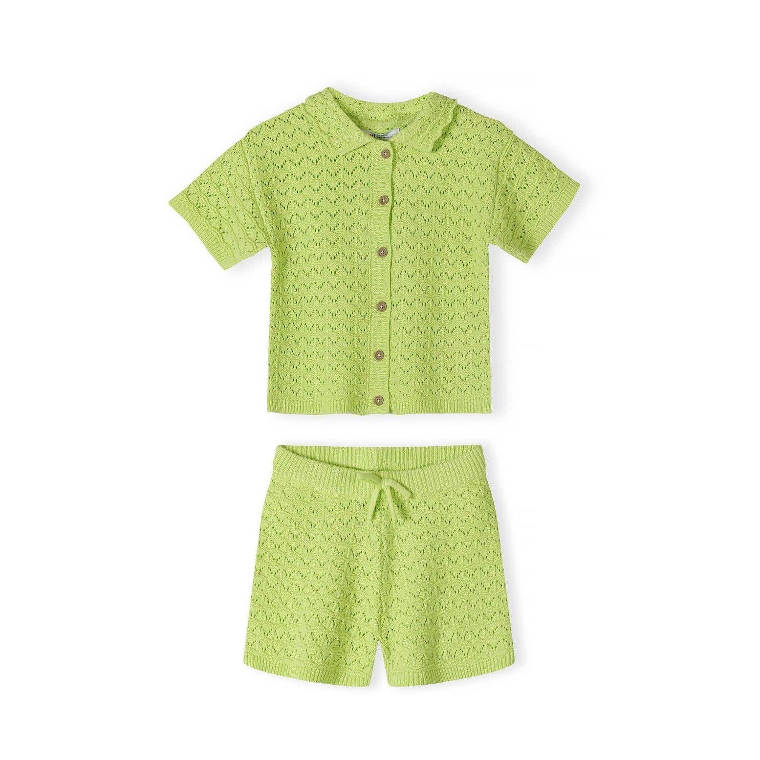 Close-up detail of lime green pointelle knit fabric showing decorative eyelet pattern, button placket with matching buttons, and Minoti brand label