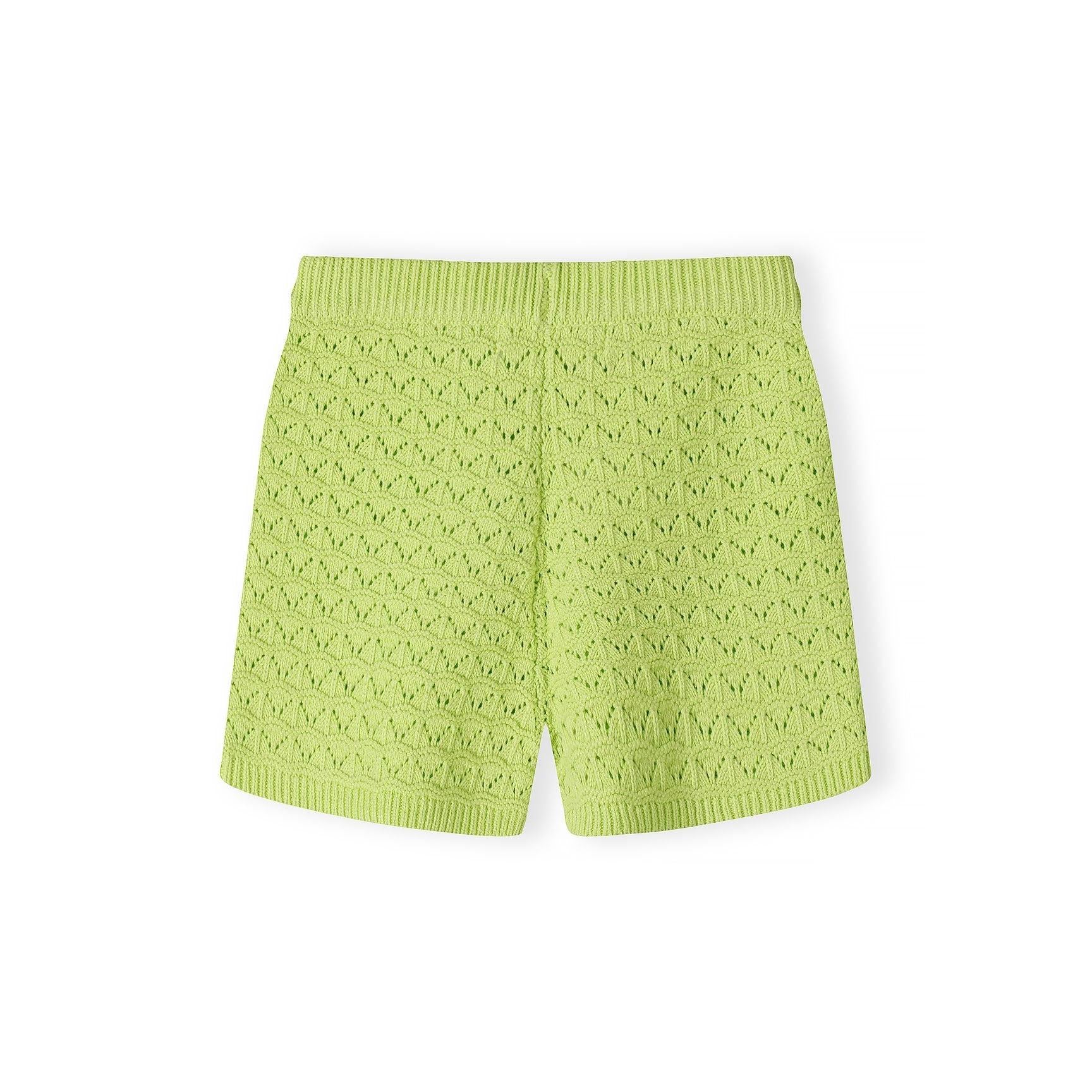 Close-up detail of lime green pointelle knit fabric showing decorative eyelet pattern, button placket with matching buttons, and Minoti brand label