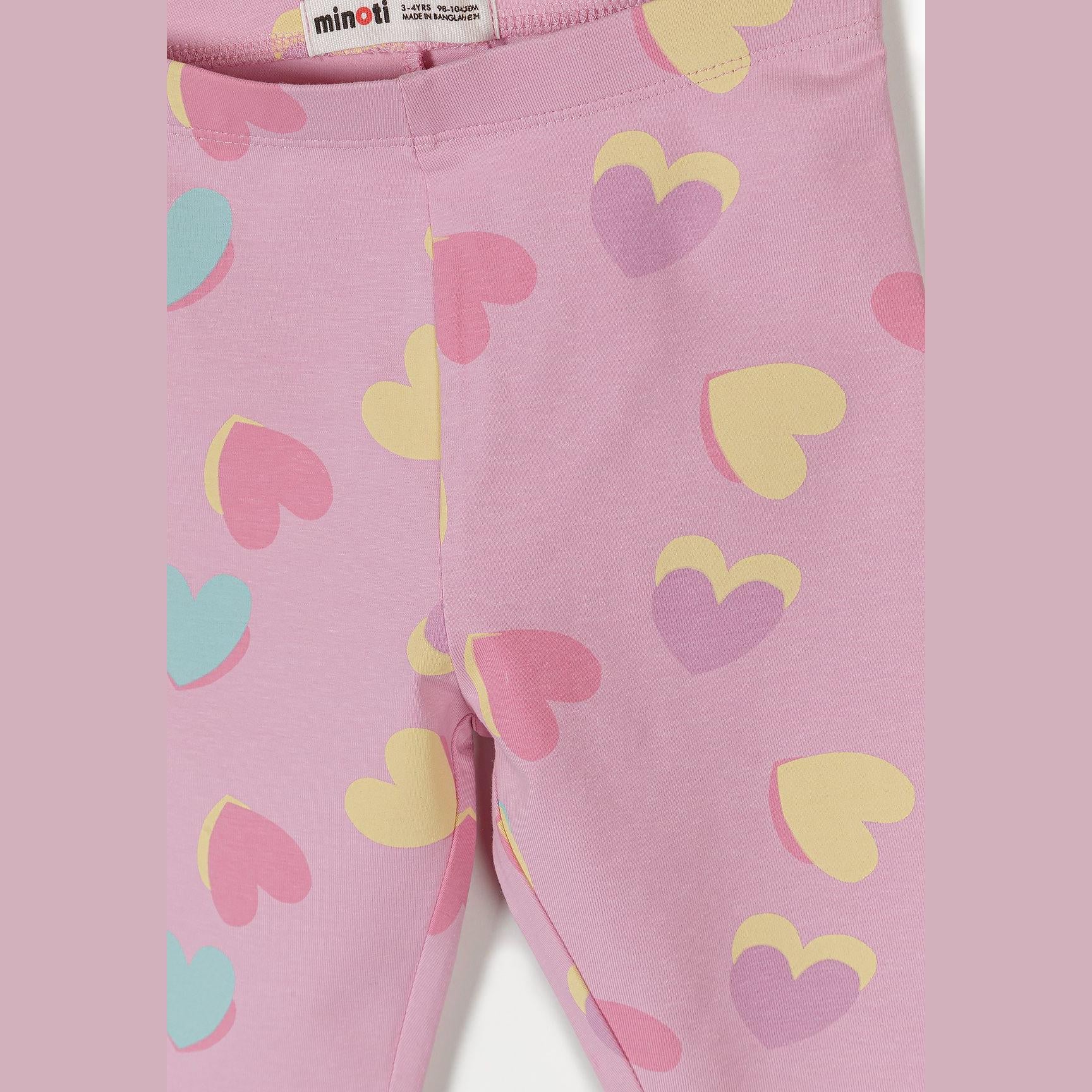 Close-up detail of pink leggings showing colorful heart print pattern with hearts in yellow, pink, purple and mint green colors