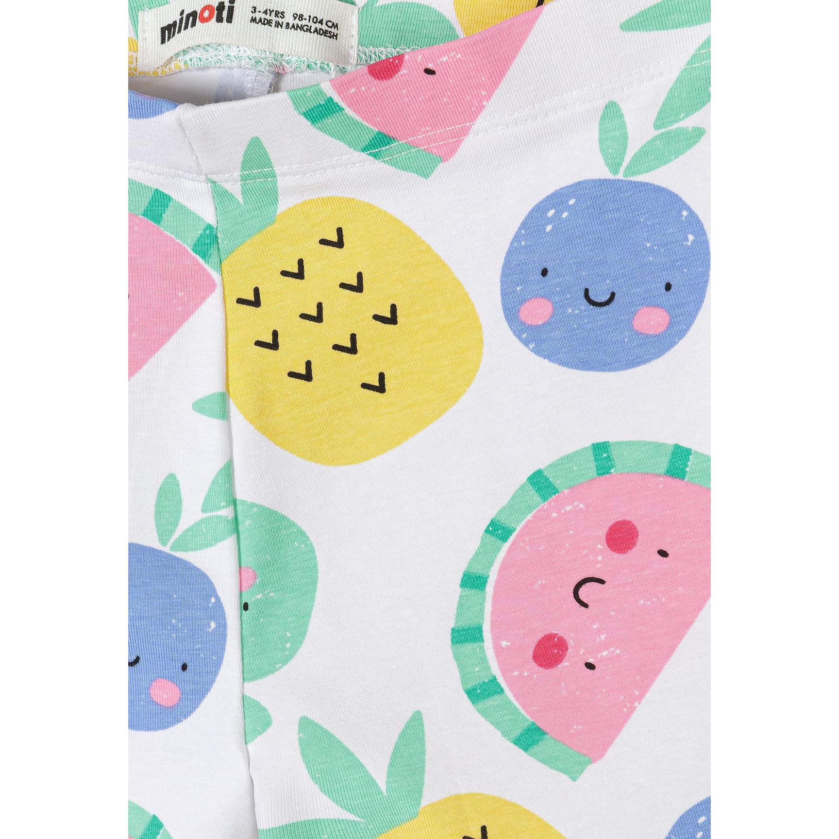 Close-up detail of white leggings with colorful fruit print showing smiling pineapples, watermelons and blueberries with Minoti label visible