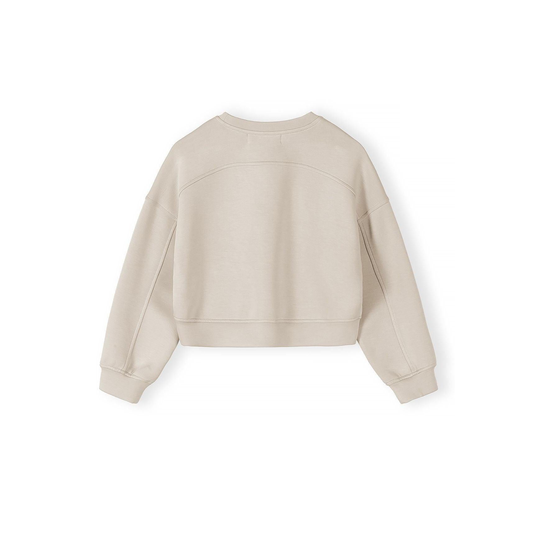 Close-up detail of beige shorts showing elasticated waistband with drawstring ties on neutral background