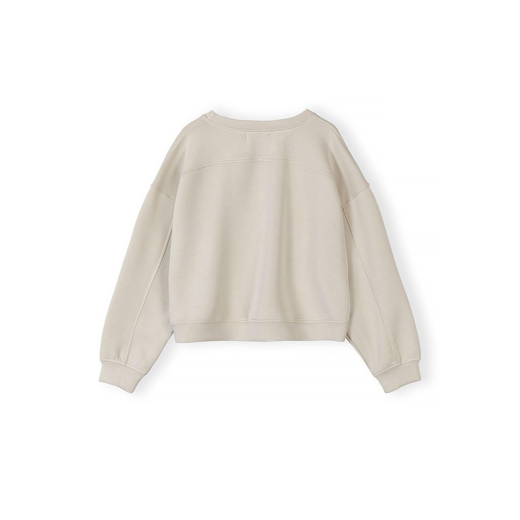 Detail shot of beige shorts waistband and pocket construction with Minoti label visible