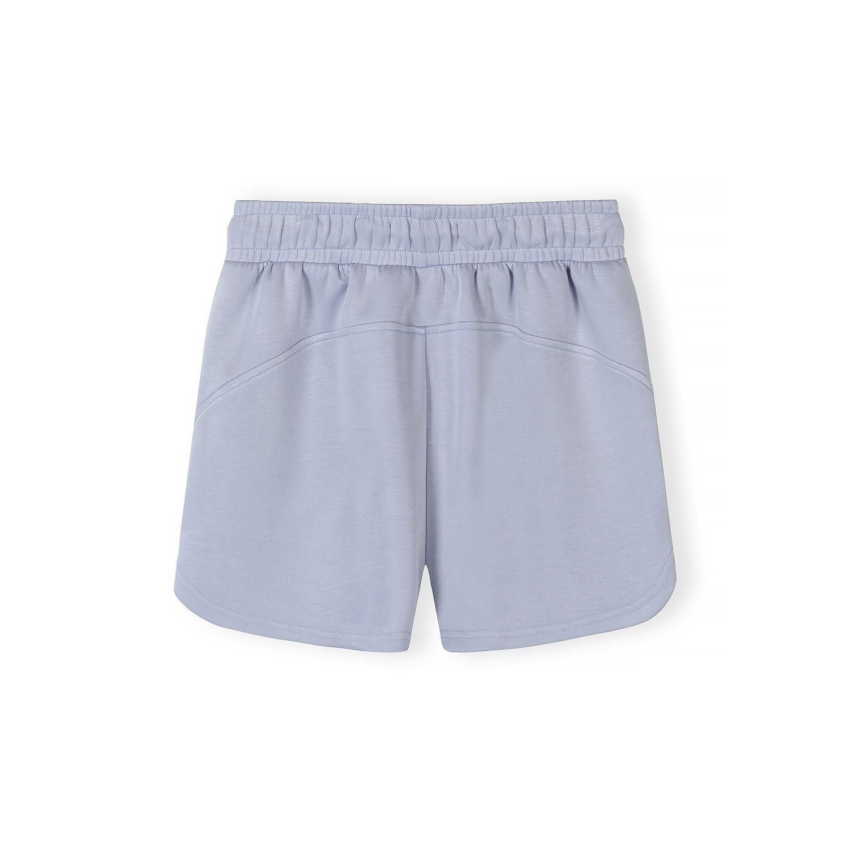 Detail view of shorts waistband showing Minoti label, elastic band and drawstring ties