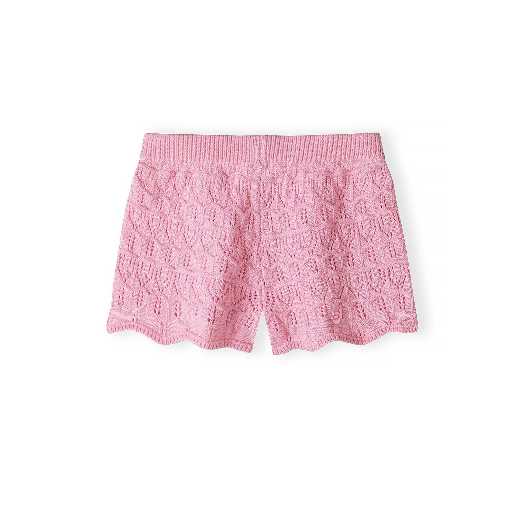 Close-up detail of pink crochet fabric showing intricate openwork stitch pattern with ribbed trim at top edge