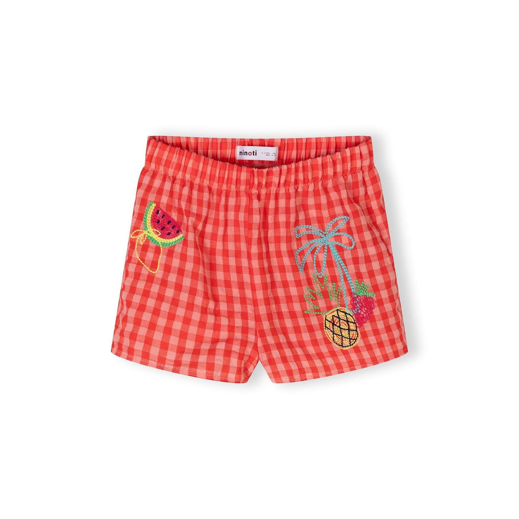 Detailed close-up showing colourful embroidered fruit designs including watermelon and other fruits on red gingham fabric