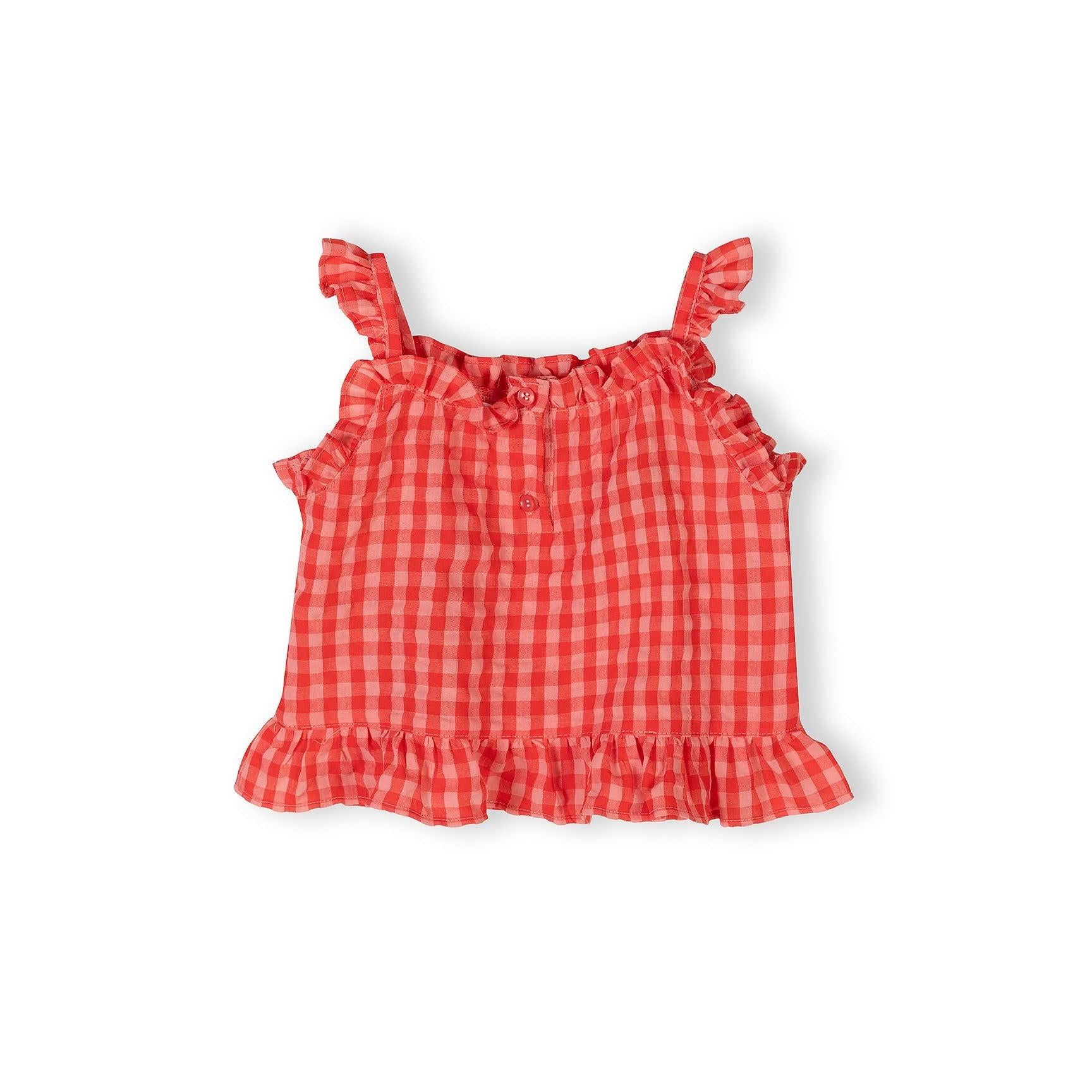 Close-up flat lay of red gingham sleeveless top with ruffle straps and button details on white background