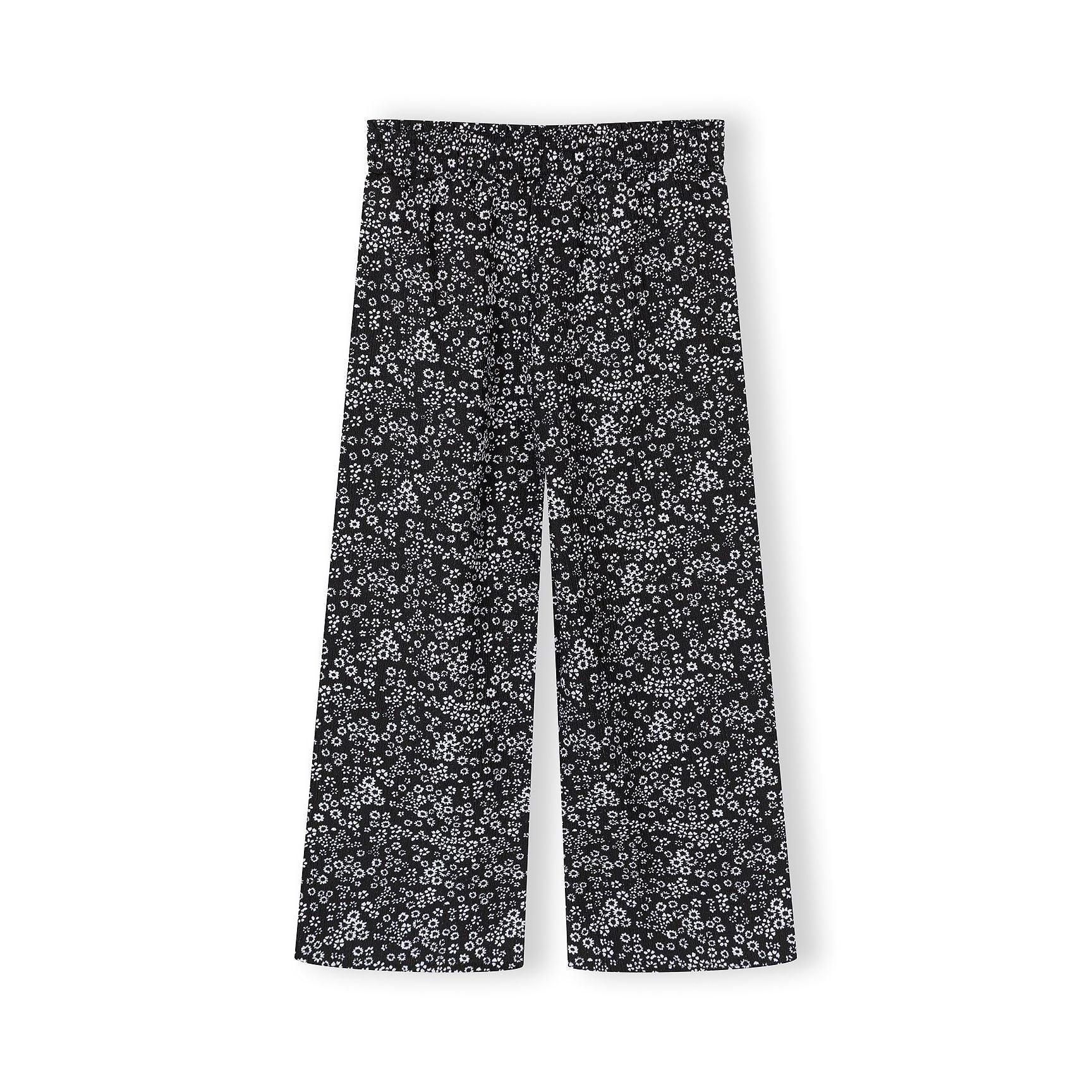 Detail shot of black sleeveless top showing Minoti label and small white floral print pattern on jersey fabric