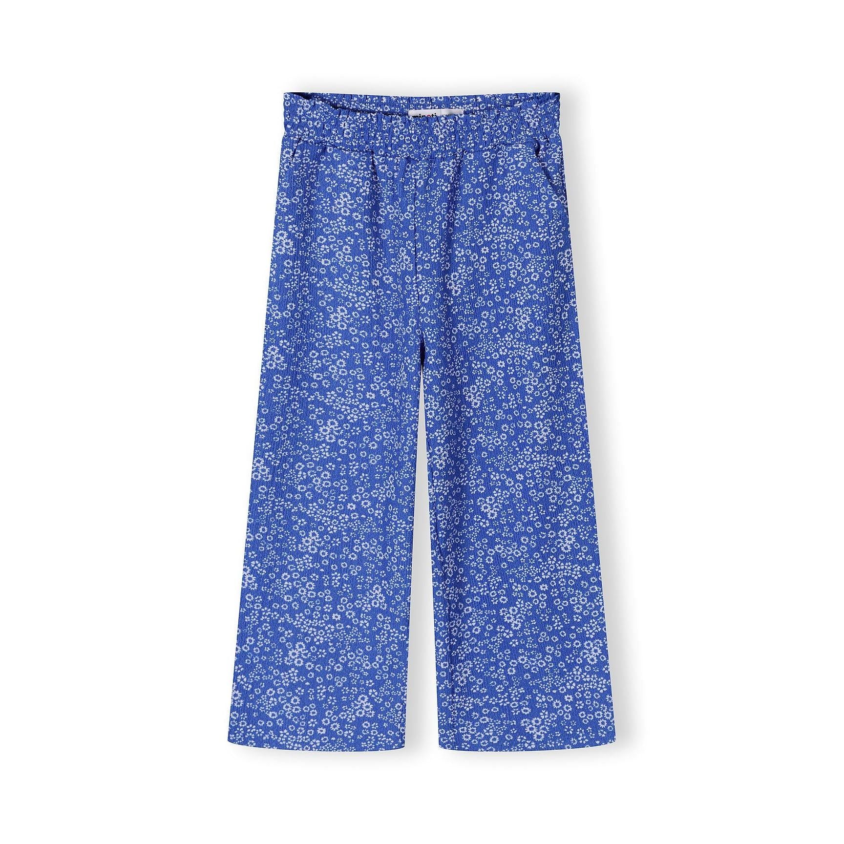 Wide-leg blue trousers with small white floral print displayed flat on white background, showing elastic waistband and relaxed fit