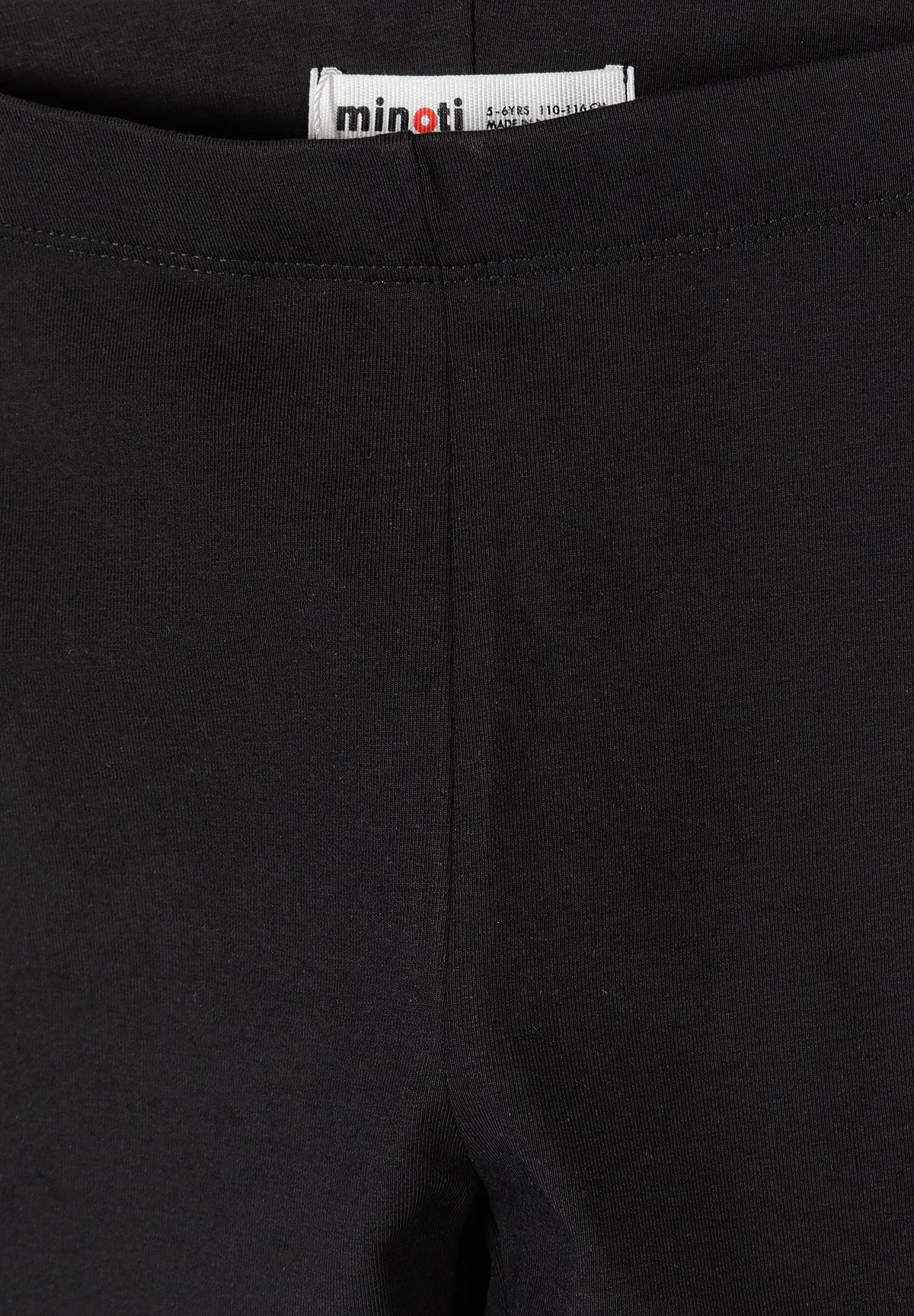 Close-up of black cycling shorts' waistband, Minoti label and fine ribbed knit.