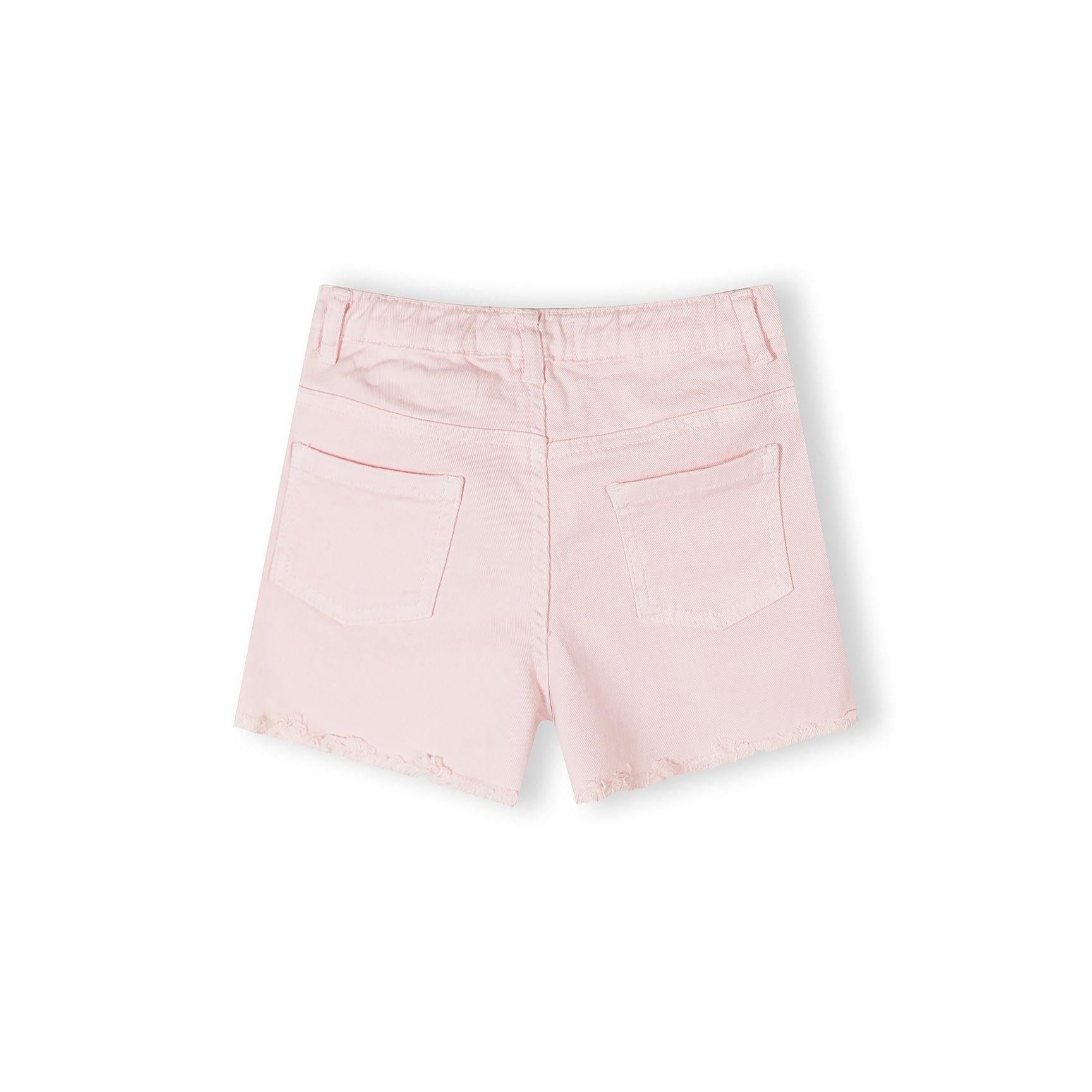 Close-up detail of beige shorts waistband showing Minoti label with size information, button fastening, and classic belt loops on neutral background