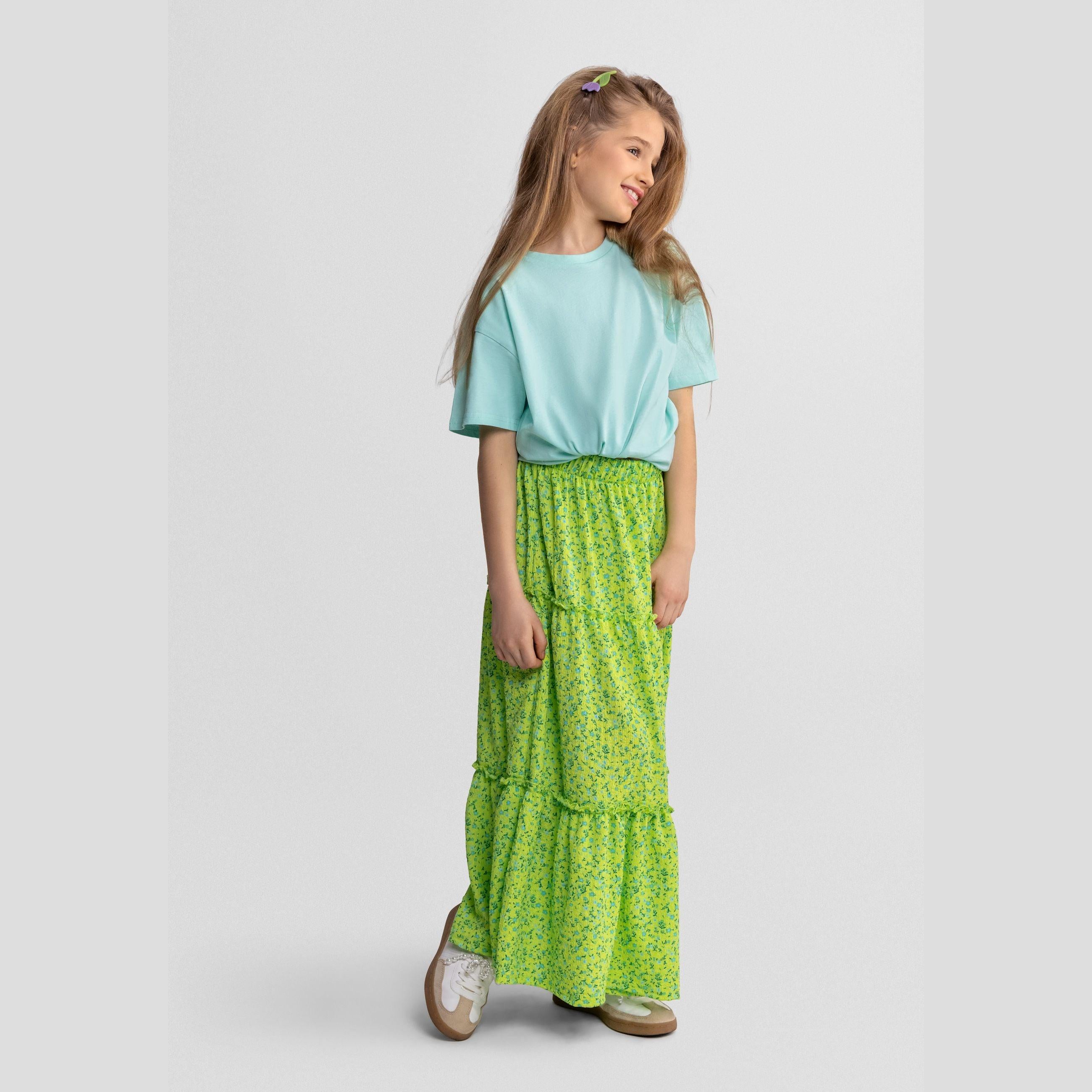 Close-up detail of green floral fabric showing blue and teal flower pattern with gathered ruffle seam and Minoti label