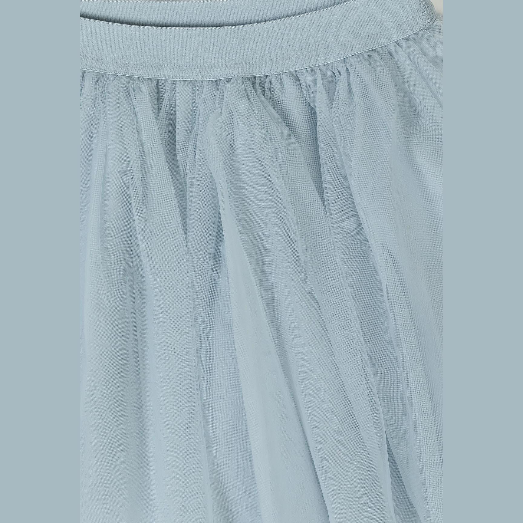 Detail shot of grey tulle fabric showing the delicate pleated texture and waistband construction of the maxi skirt