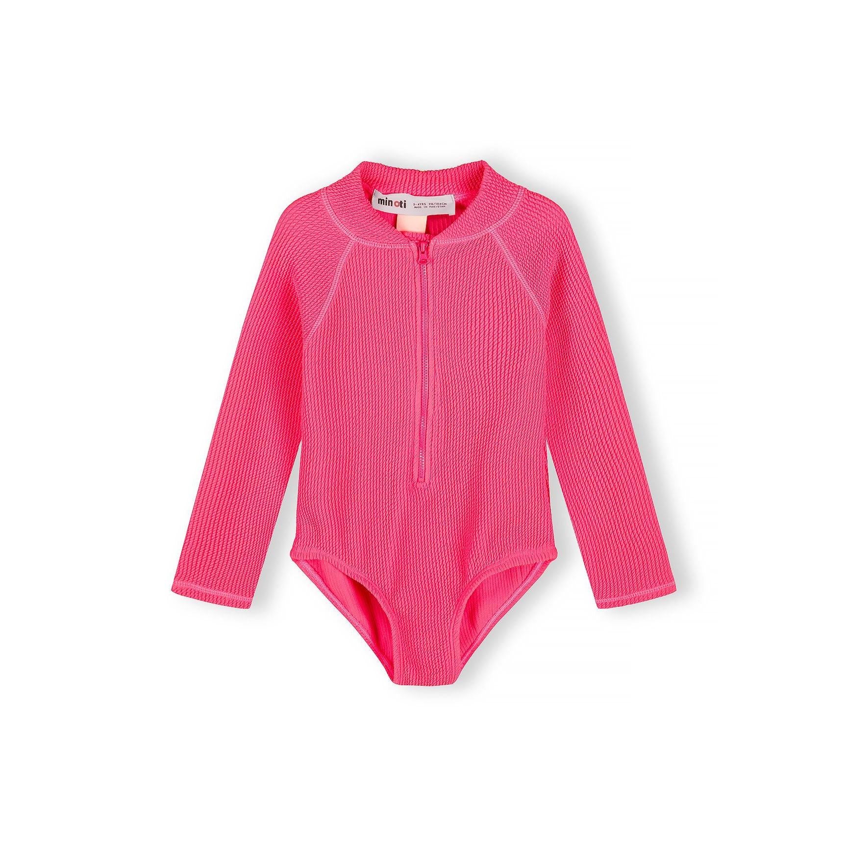 Bright pink long sleeve swimsuit with front zip closure displayed flat on white background, showing ribbed texture and Minoti label