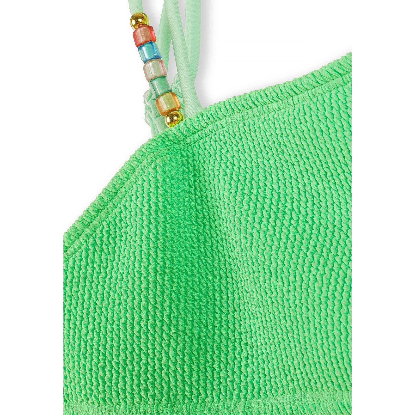 Close-up detail of emerald green textured bikini top showing beaded shoulder strap with colourful decorative beads