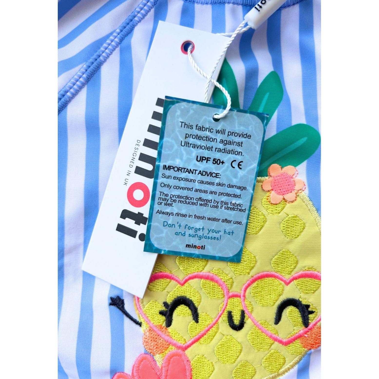 Blue and white striped rash vest set with pineapple character wearing heart-shaped sunglasses, showing UPF 50+ care label and Minoti branding tag