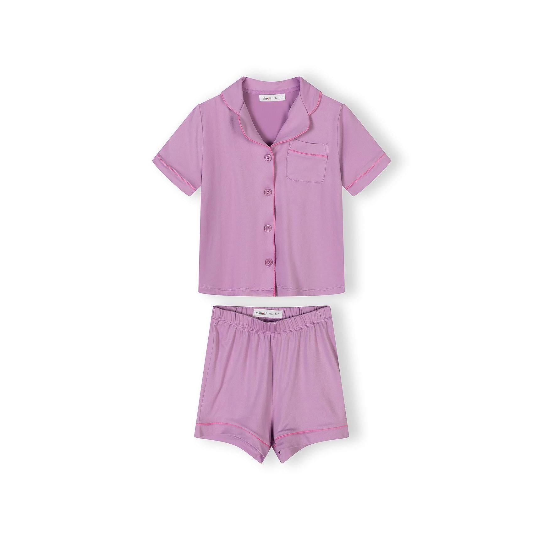 Close-up detail of pink pajama top with colorful heart pattern and white piping trim around collar and pocket