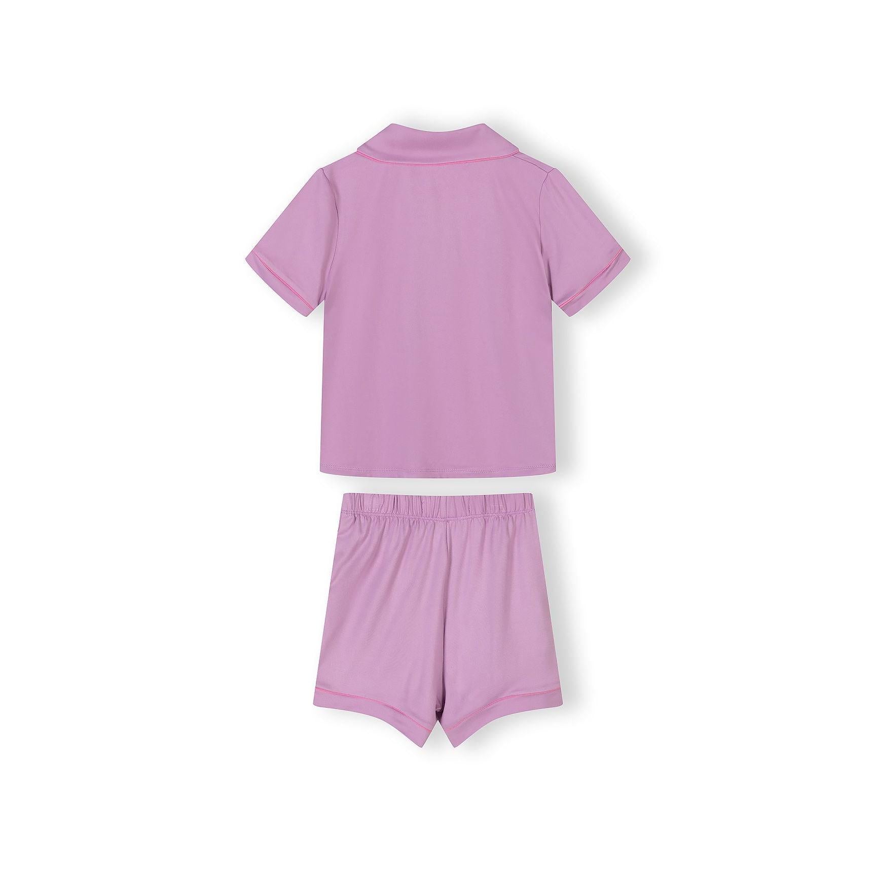 Close-up detail of pink pajama top with colorful heart pattern and white piping trim around collar and pocket