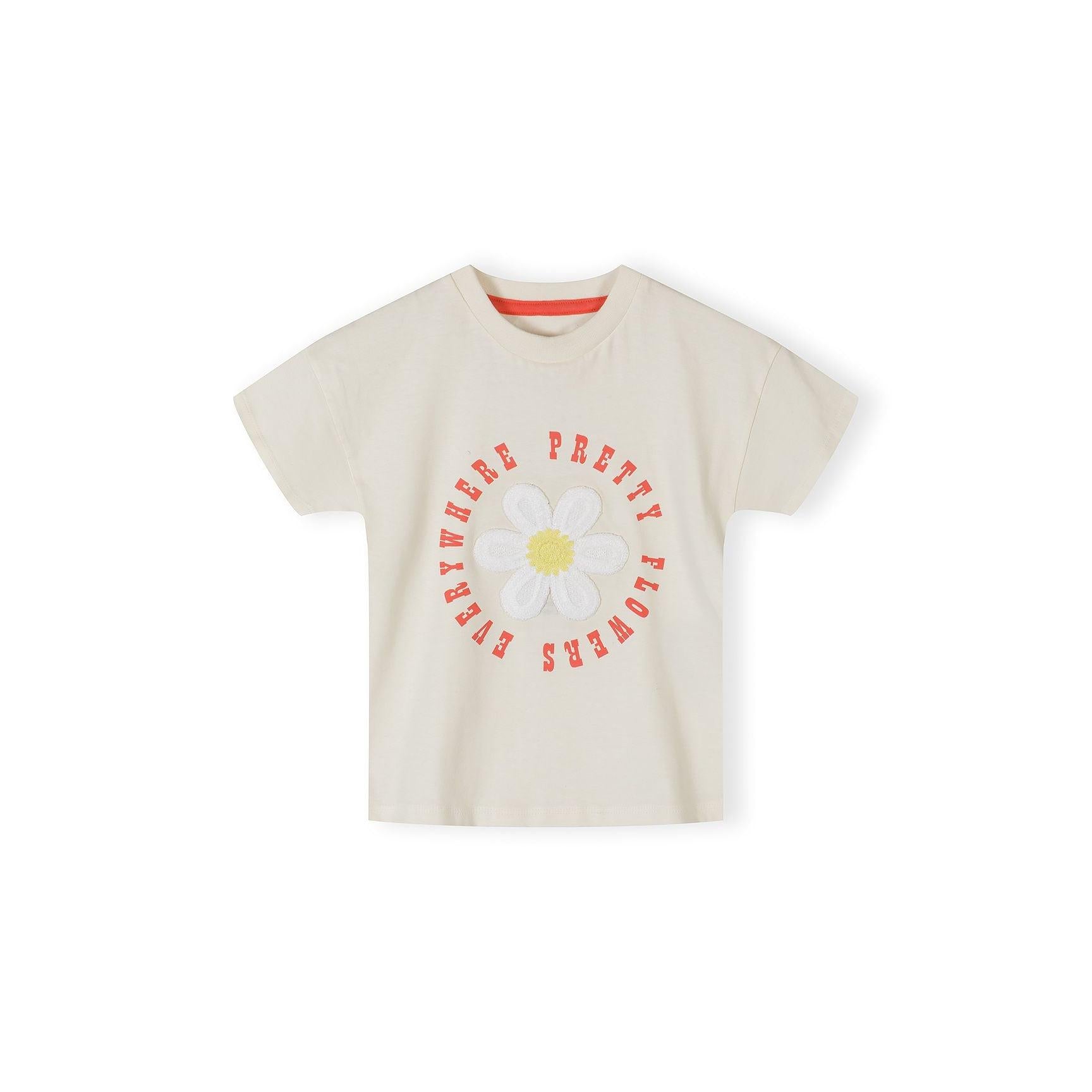 Cream cotton t-shirt with crochet flower detail displayed flat against white background, showing front view with coral neckline trim